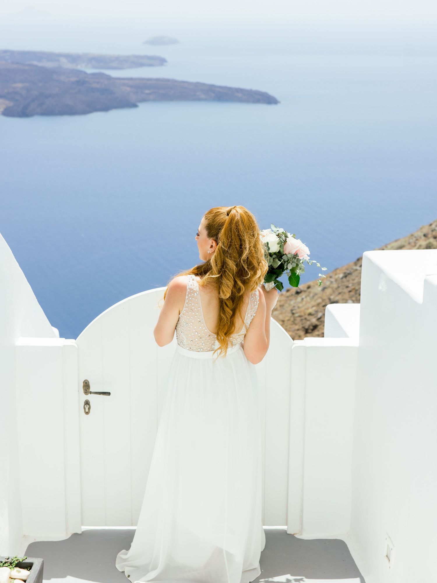 White architecture and ocean views of Santorini with bright blue Mediterranean sea.