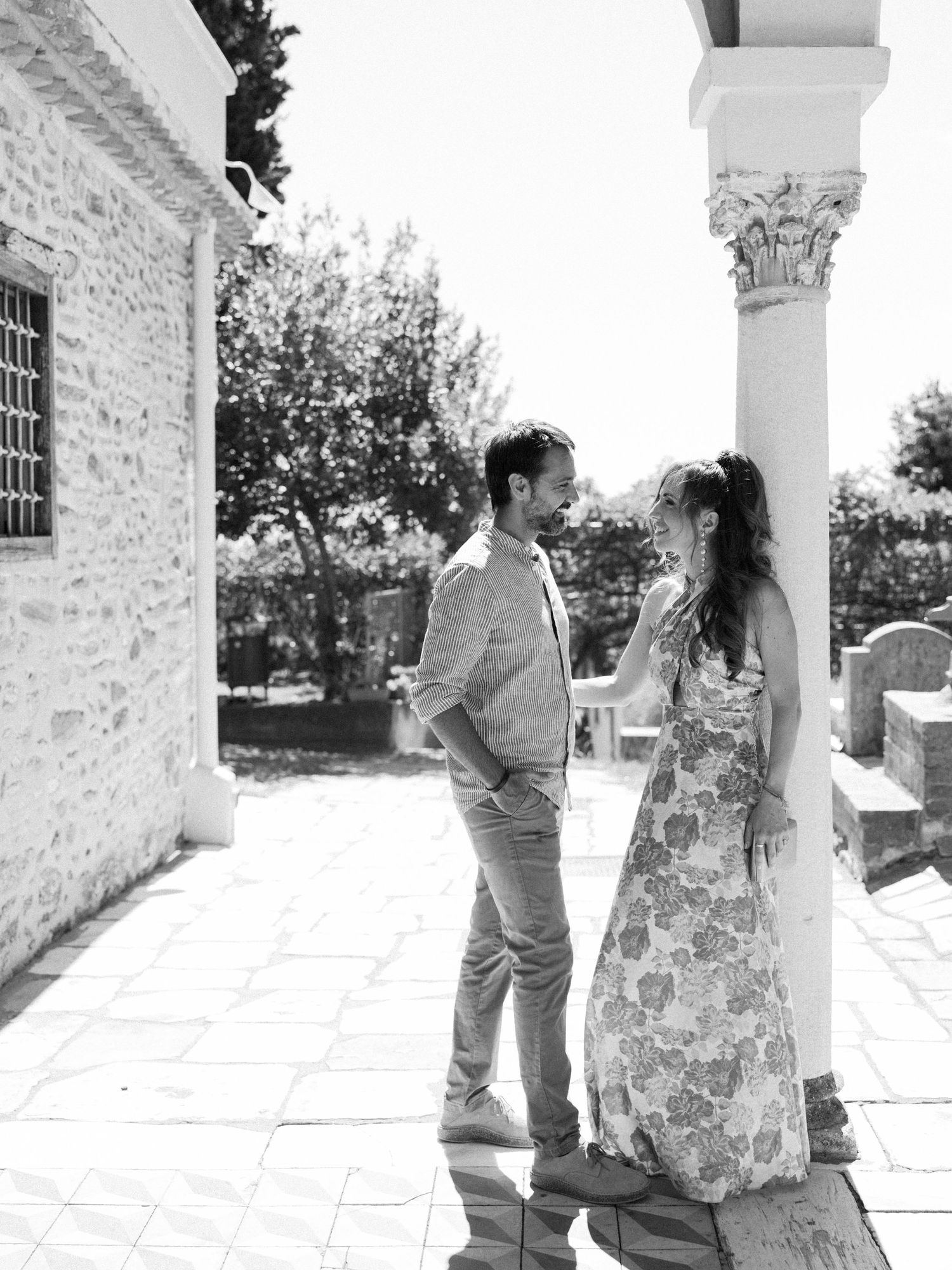 A black and white photo series showing a couple's romantic proposal moment on a white stone porch.