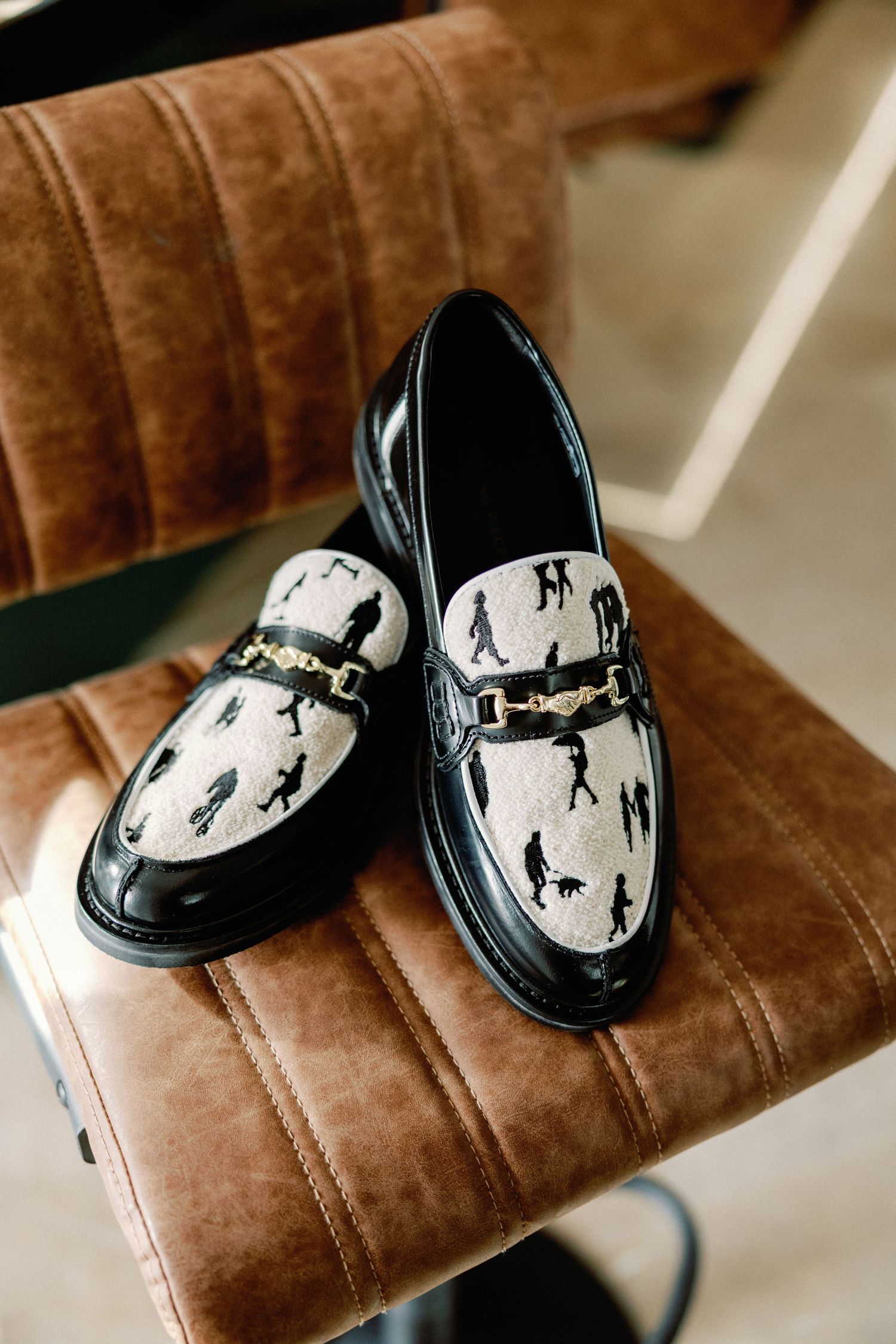 Stylish loafers with black and white pattern featuring silhouettes of people.