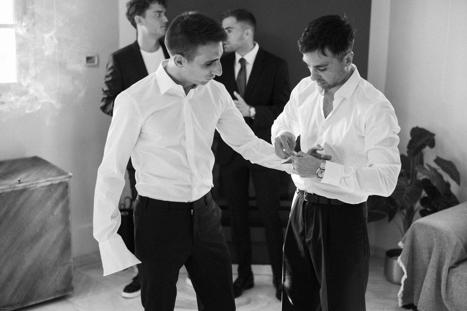 Wedding preparations with people in formal attire getting ready indoors.