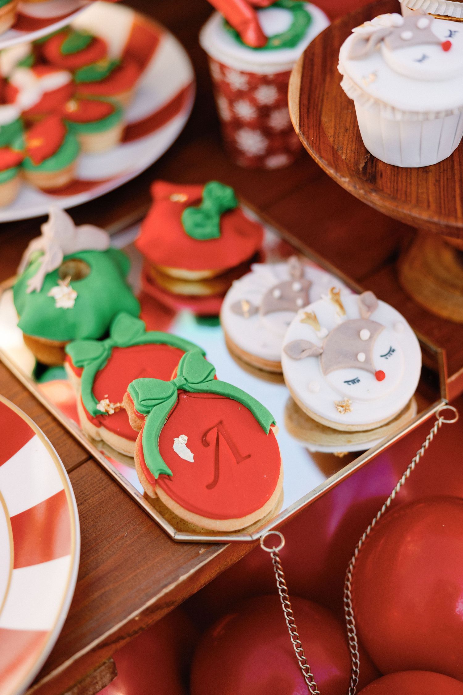 Christmas cookies decorated with red and green frosting arranged on a wooden surface with festive holiday designs.