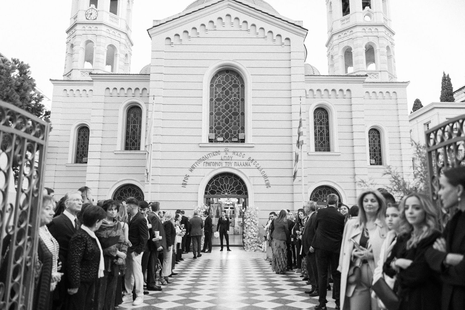 White church facade with guests lined up outside during wedding ceremony.