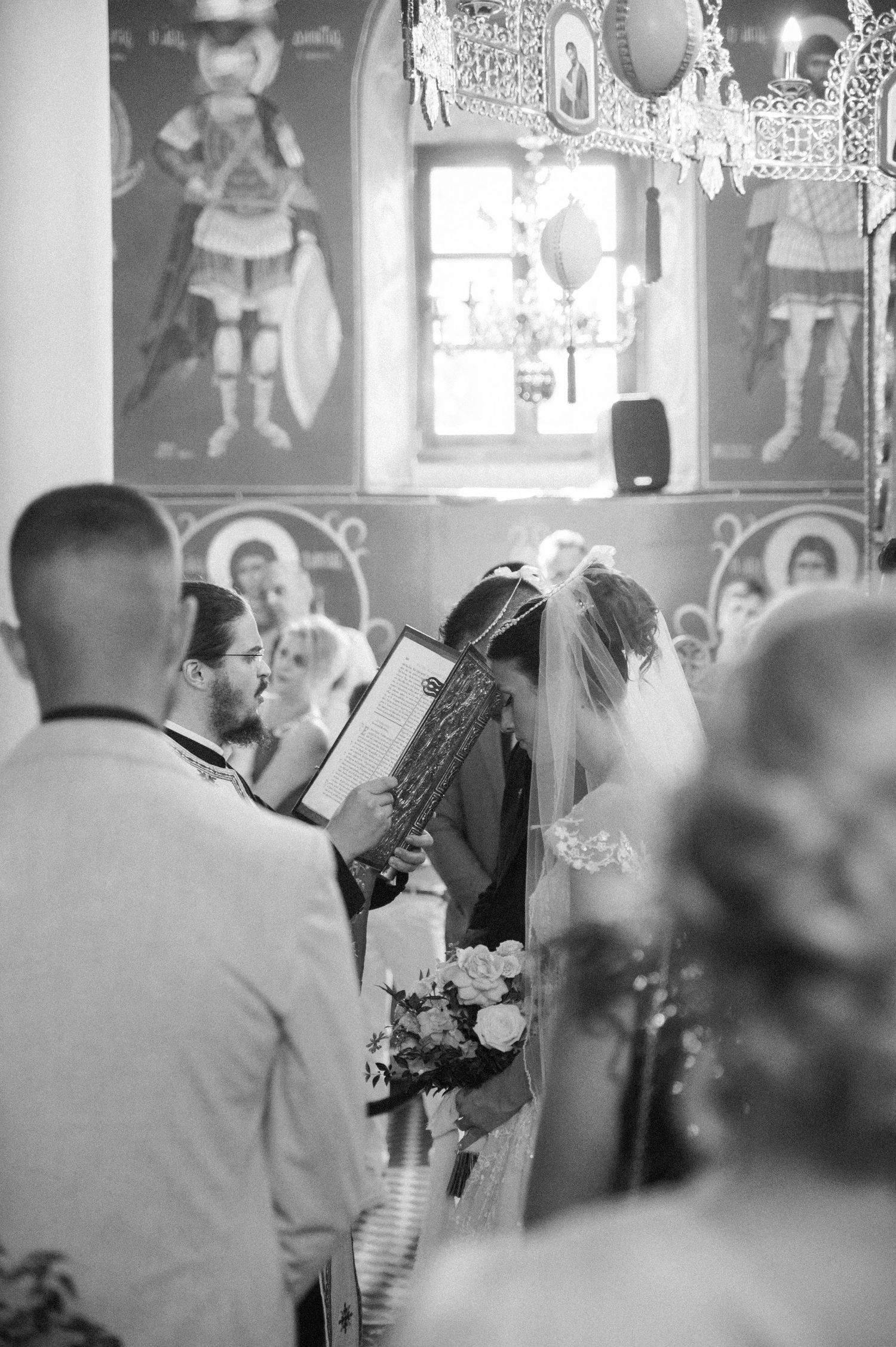 Black and white candid shots of a wedding ceremony inside a decorated venue.