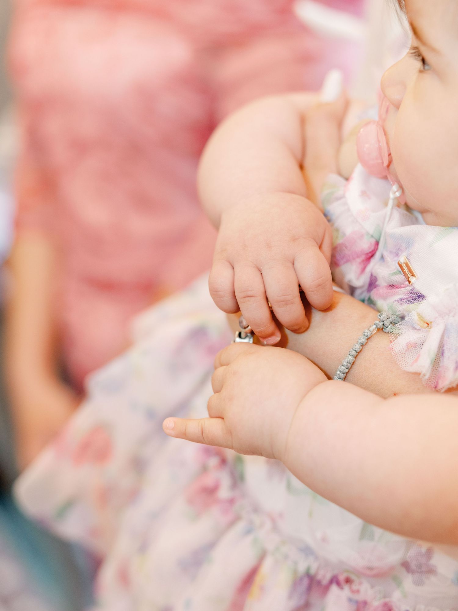 Close-up view of hands measuring a baby's foot with a measuring tape for size documentation.