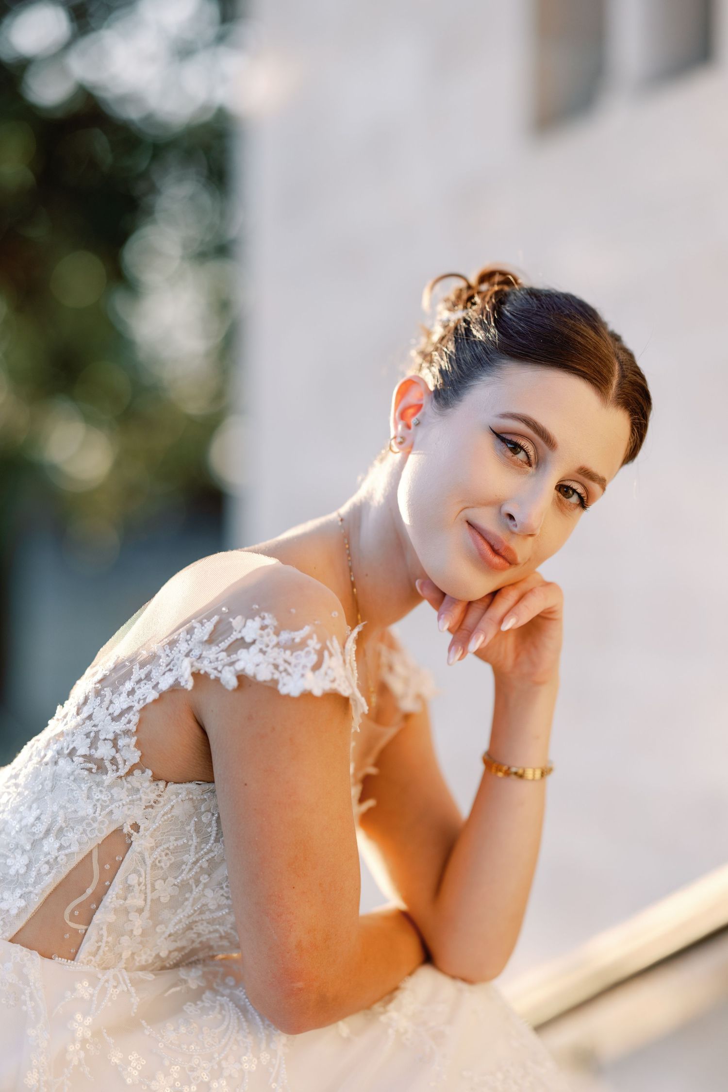 Sunlit bridal portrait featuring delicate lace dress details and soft makeup.