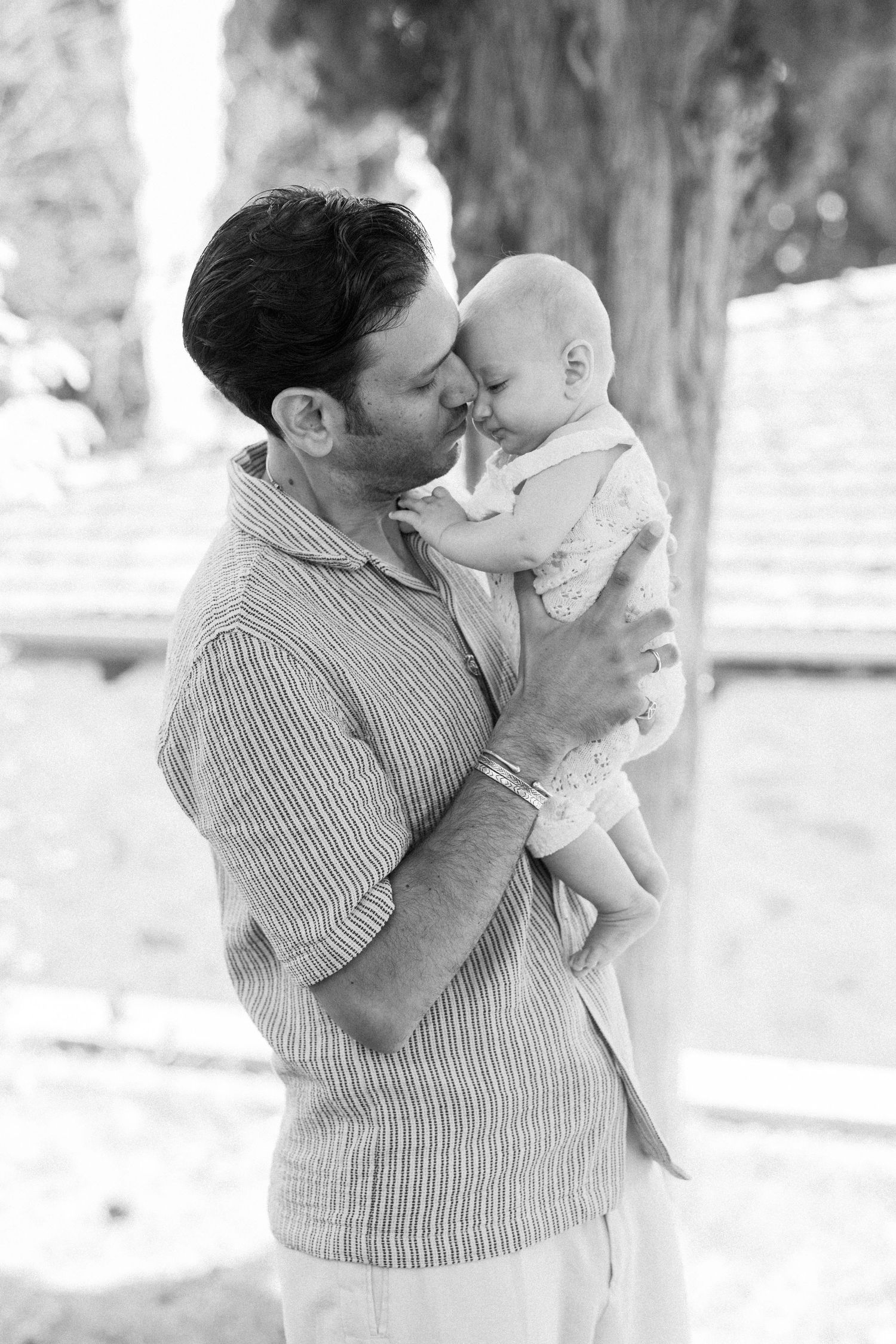 A tender black and white portrait of a caring embrace outdoors.