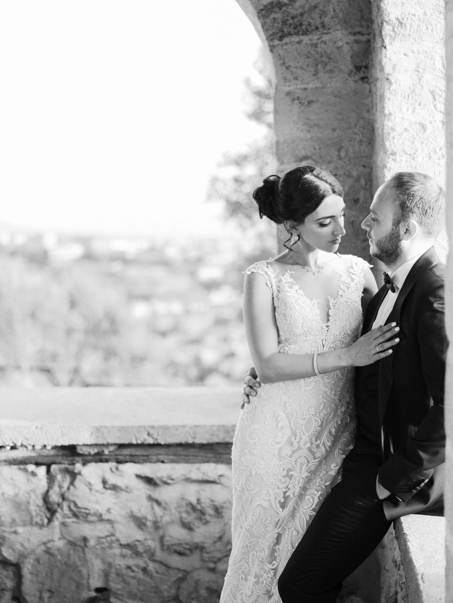 Black and white intimate wedding photos taken in a historic stone arcade.