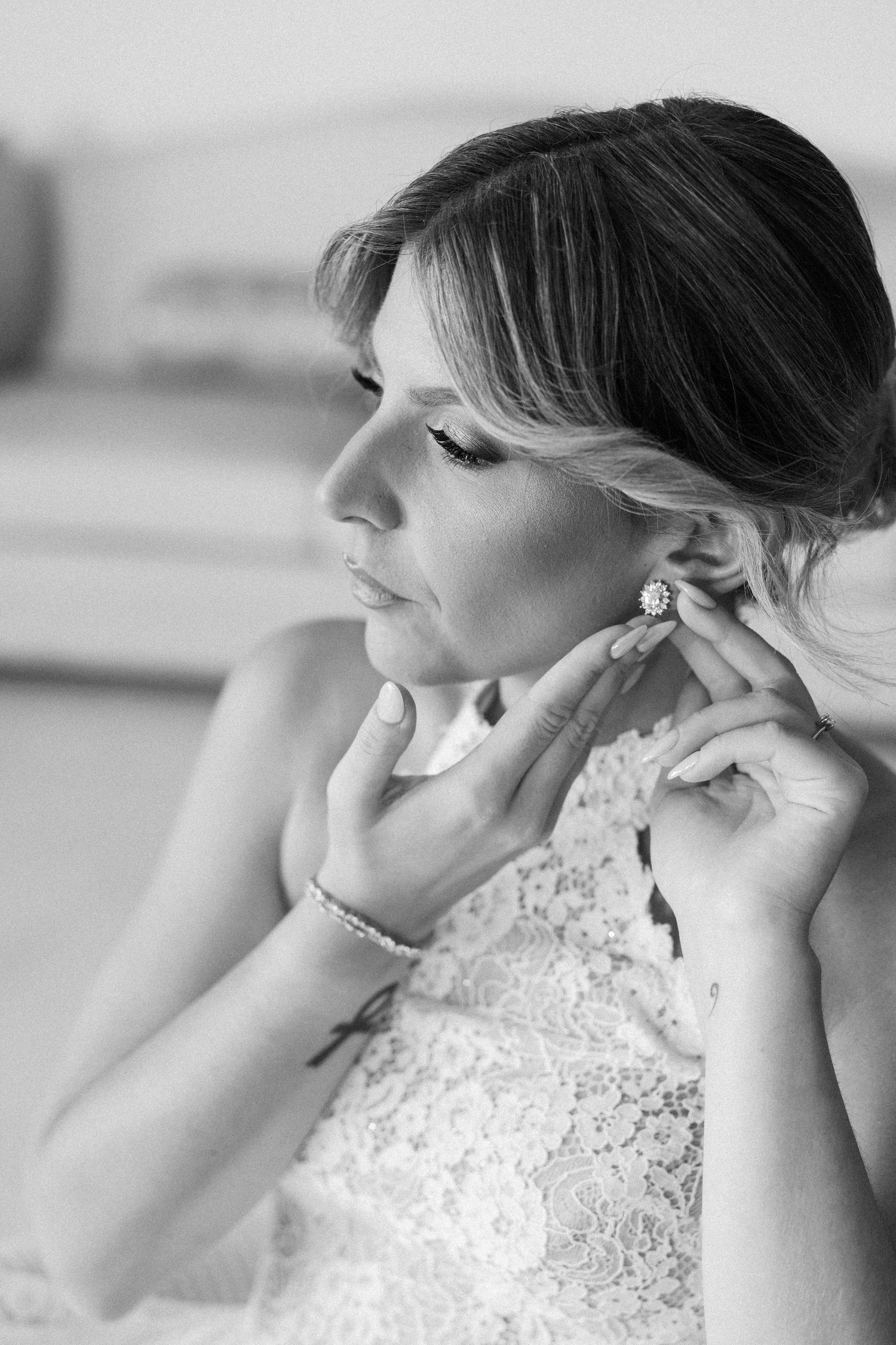 Side profile view showing elegant bridal jewelry and lace neckline details.