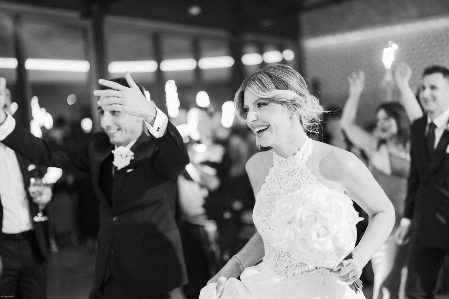 Wedding reception dance floor with guests celebrating under ambient lighting.