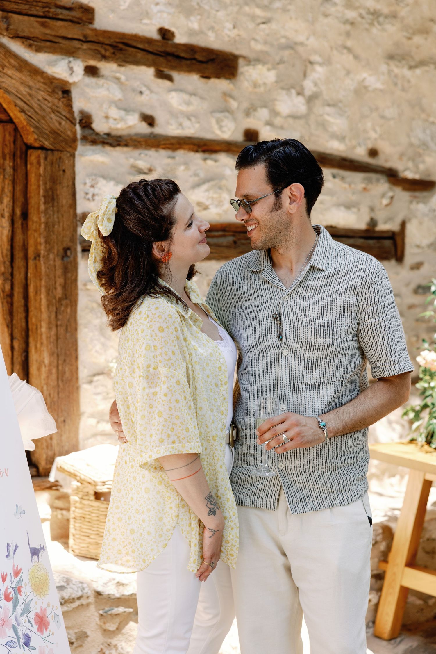 Couple sharing intimate moments in a rustic stone building with wooden beams.