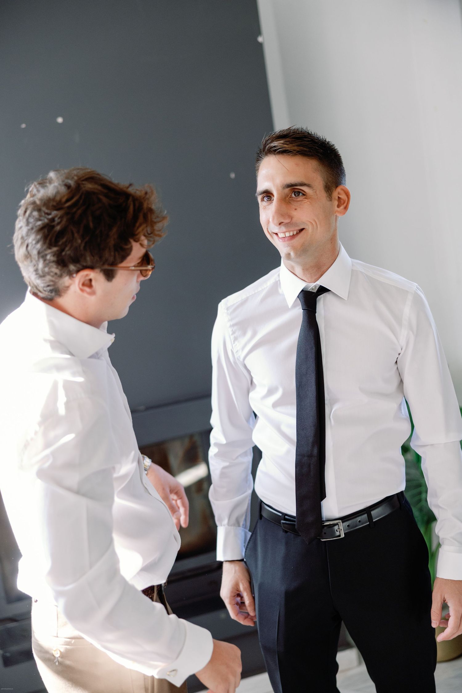 Candid moments of people in formal white shirts and ties during event preparations.