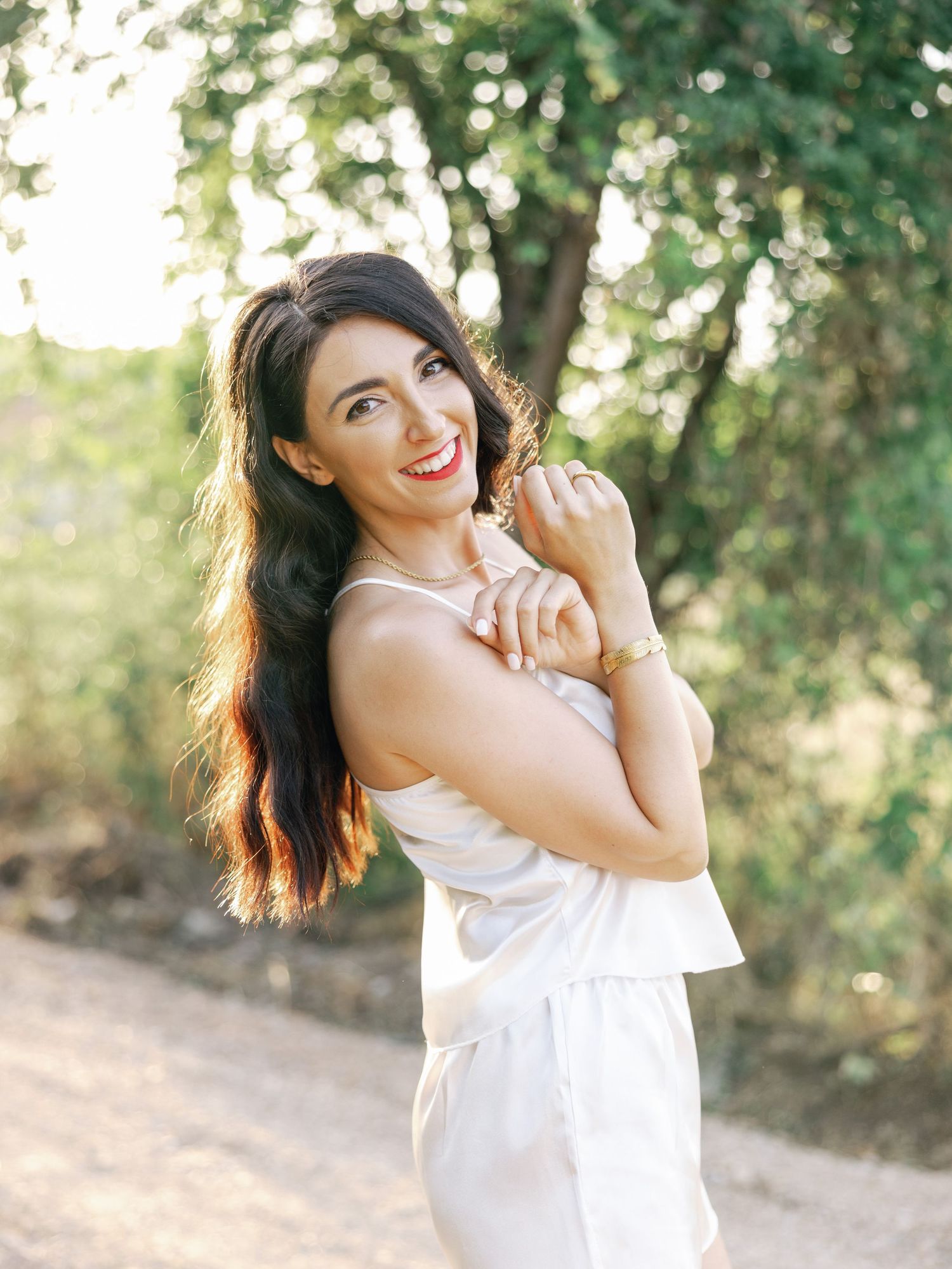 Lifestyle portraits in natural lighting with casual white top against green foliage.