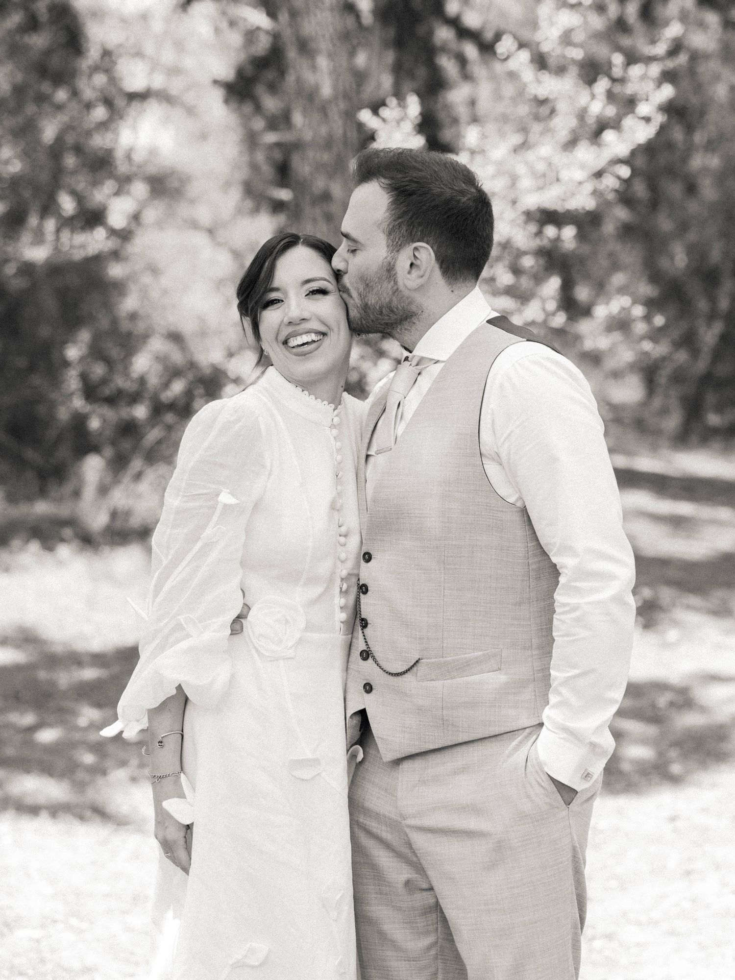 A romantic black and white photo series of a couple sharing intimate moments outdoors in casual wedding attire.