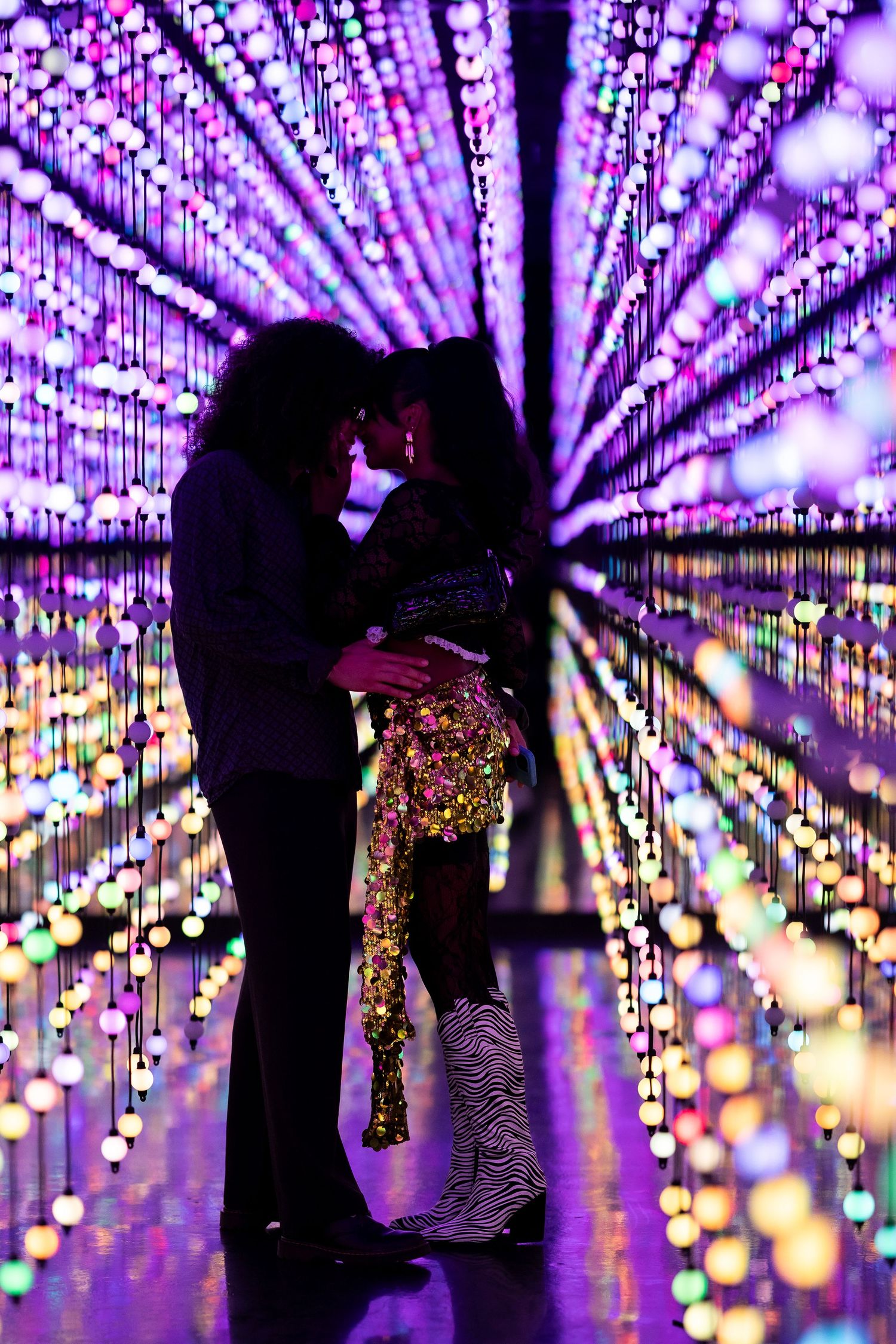 Silhouettes dance under a stunning display of purple LED lights creating a magical atmosphere.