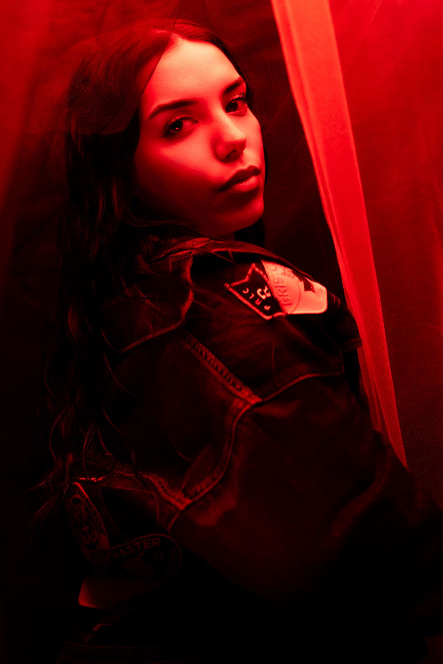 Moody portraits bathed in red lighting creating mysterious atmosphere.