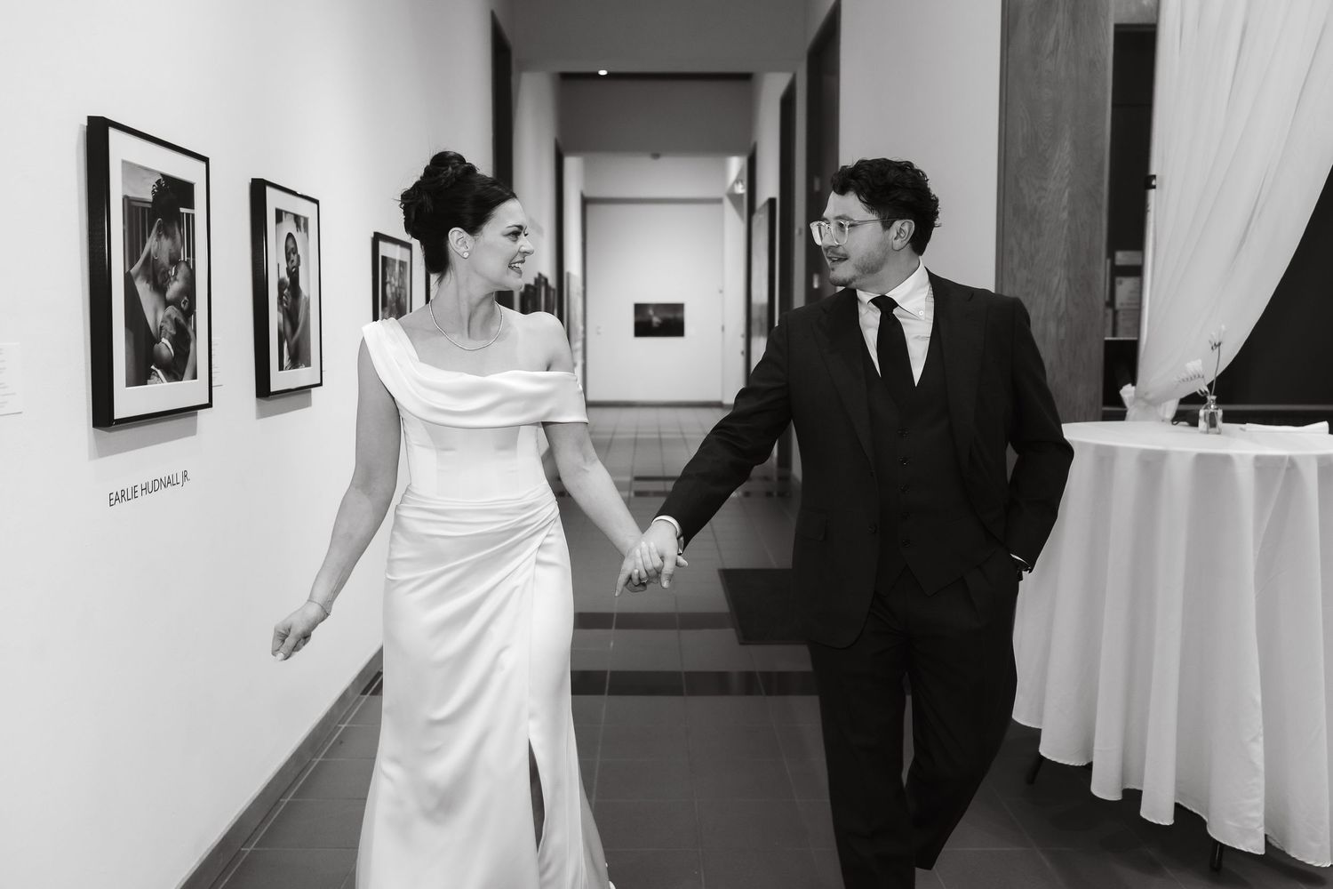 A couple dances together in an elegant indoor venue with framed artwork on the walls.