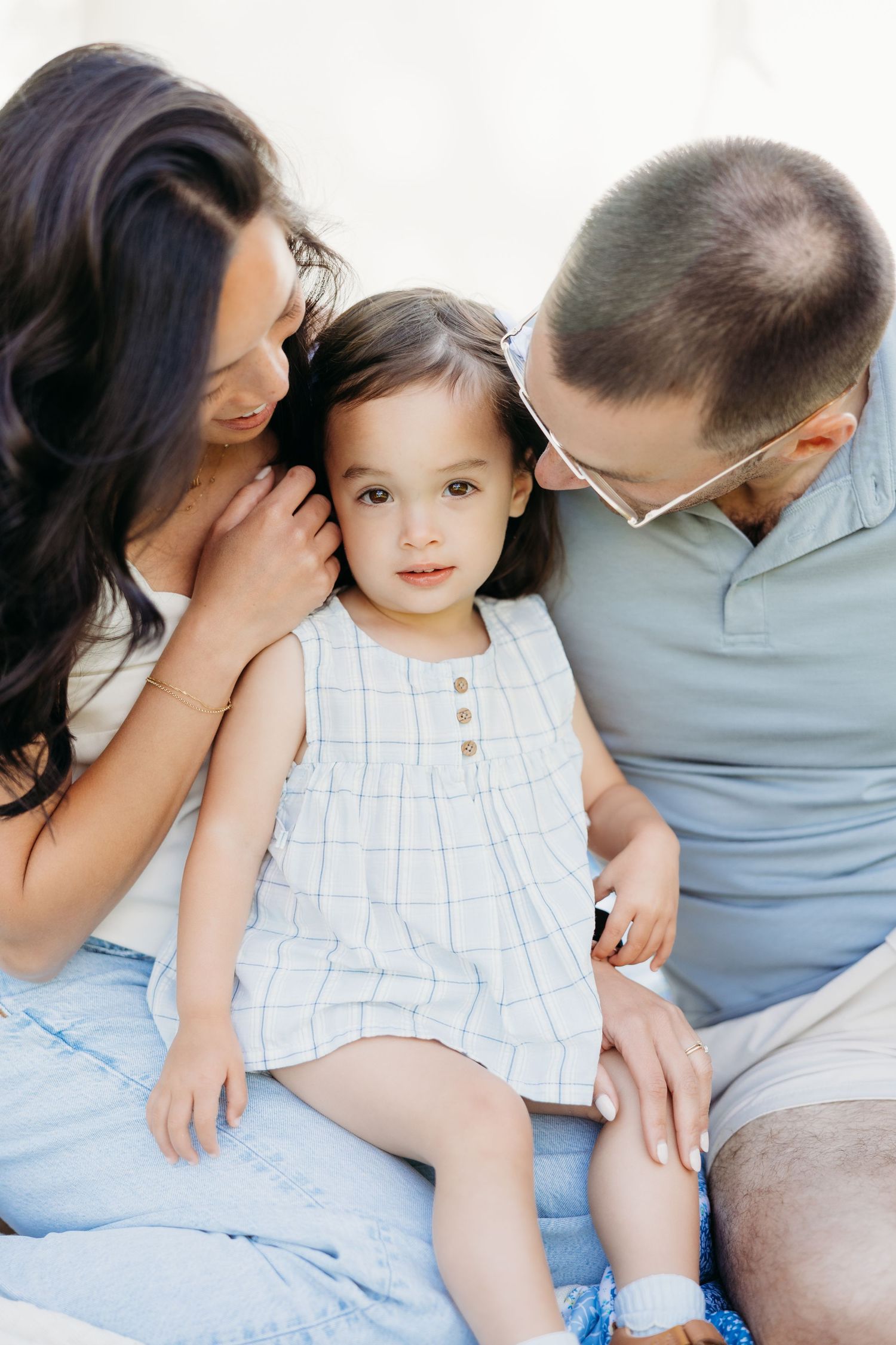Parents kissing their toddler during a playful family photography session near Dayton, Ohio.