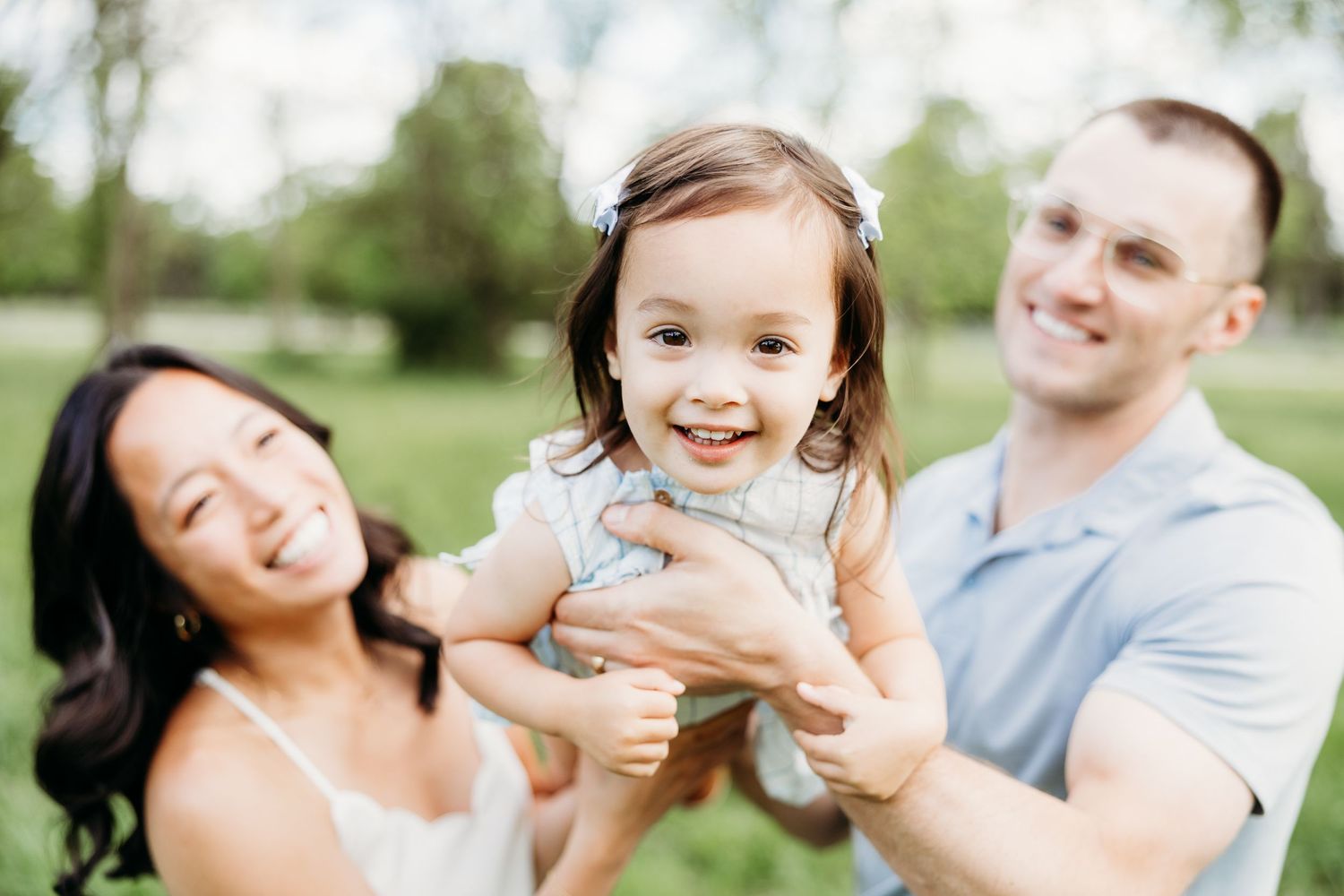 Parents playing with their toddler during a relaxed family photography session in Tipp City, Ohio.