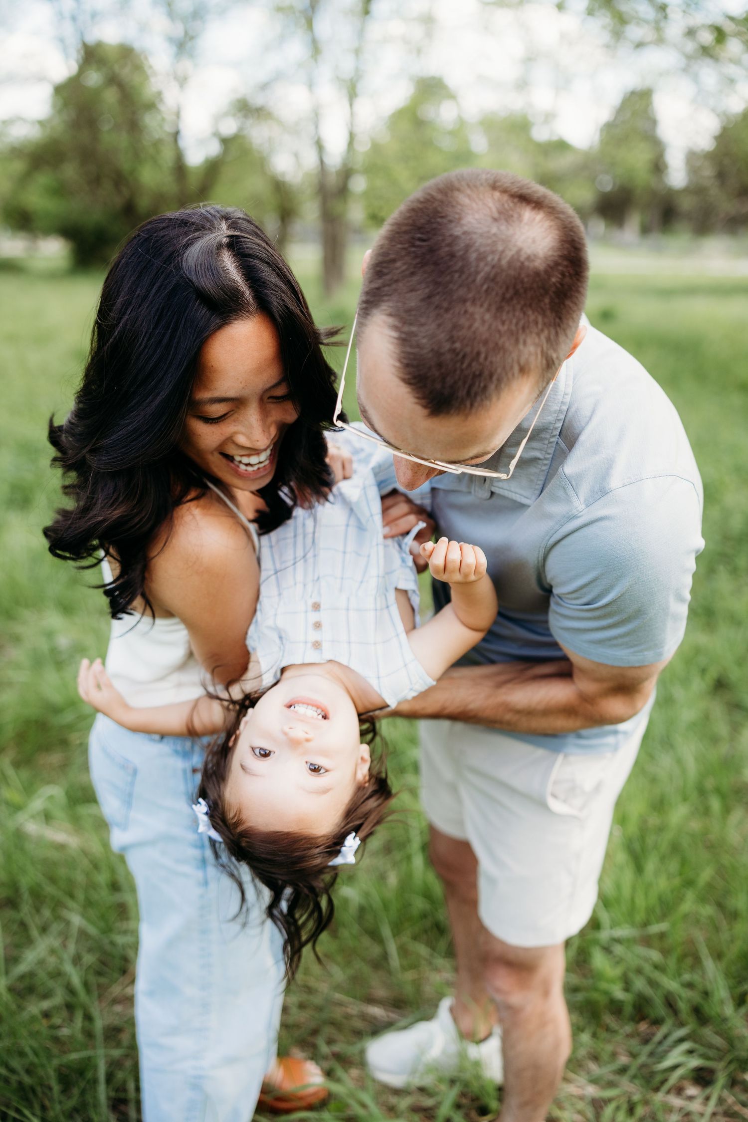 Family playing and laughing together during a fun outdoor family photo session in Tipp City, Ohio.