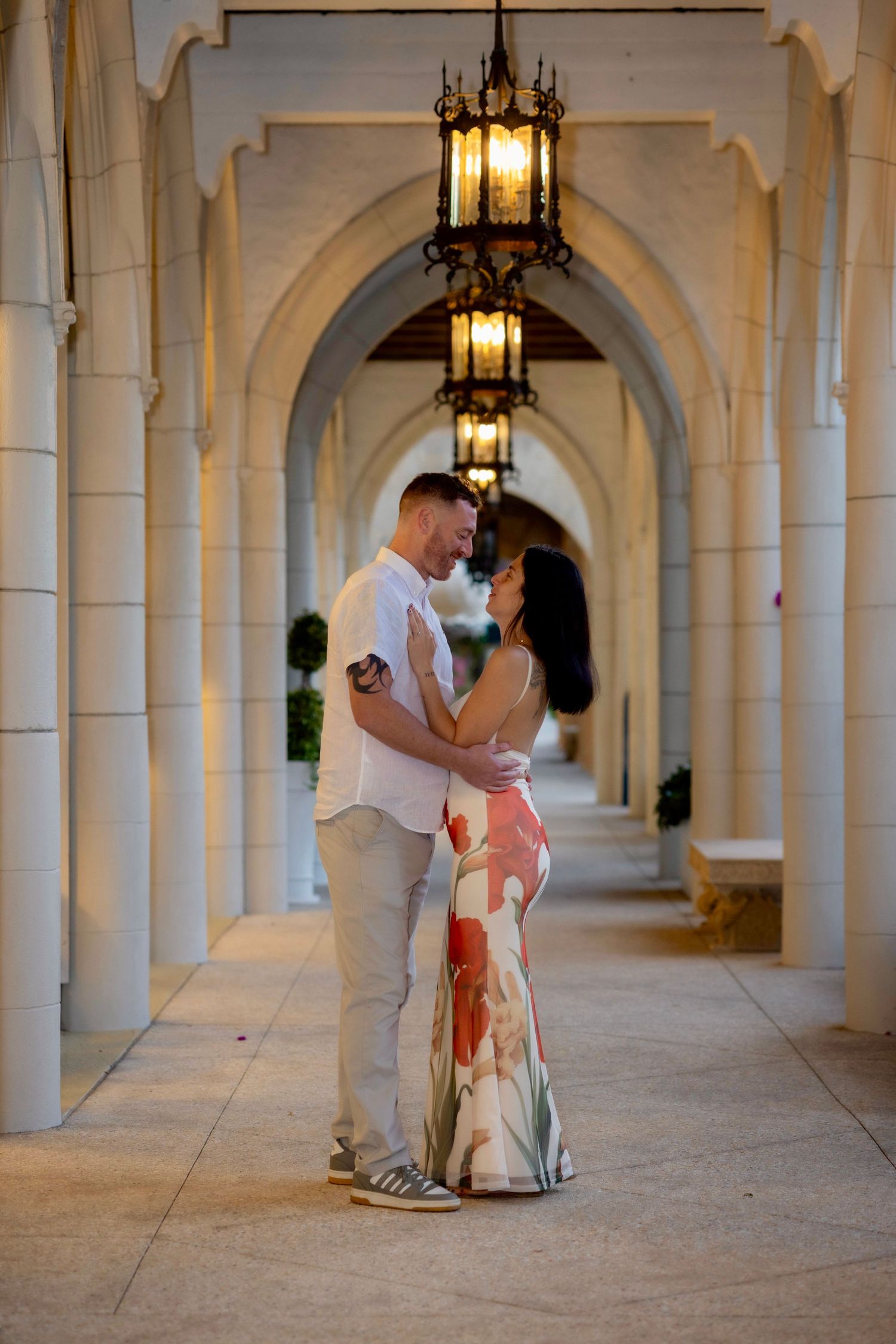 Romantic couple dancing in a beautiful arched colonnade with hanging lanterns.
