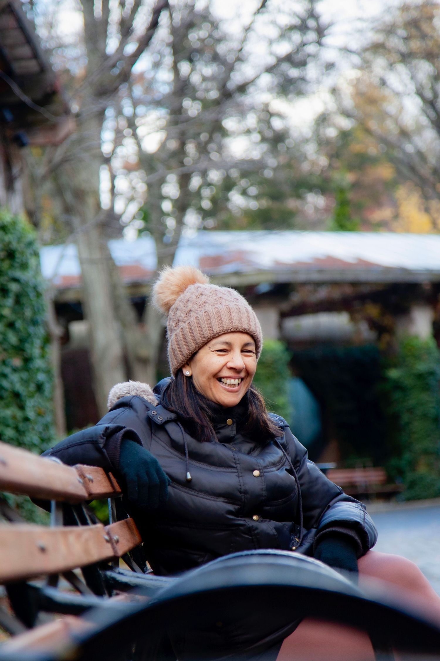 Person relaxing outdoors wearing winter hat with joyful expression.
