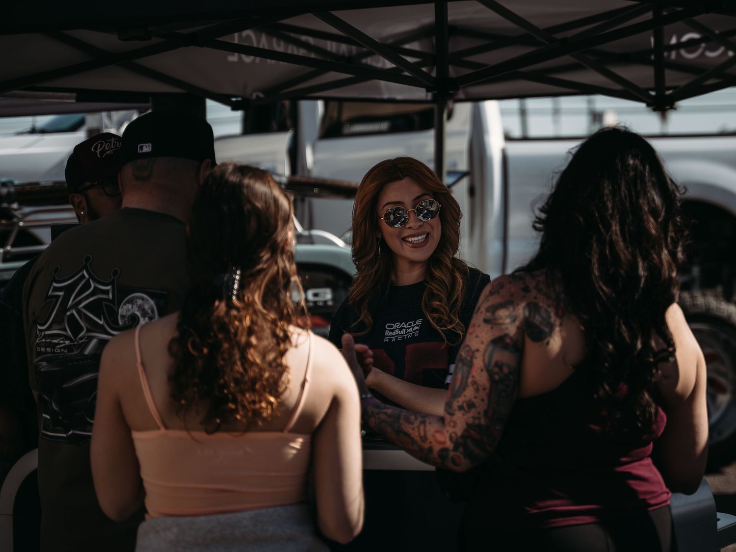 Group of tattooed women socializing under a canopy tent at Super Saturday Weekend at The STRAT in Las Vegas
