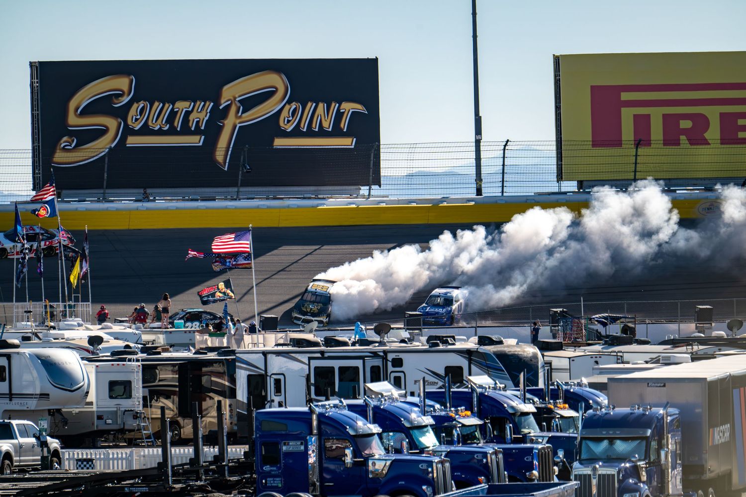 Smoke rising near South Point and Pirelli signs at Las Vegas Motor Speedway NASCAR event.