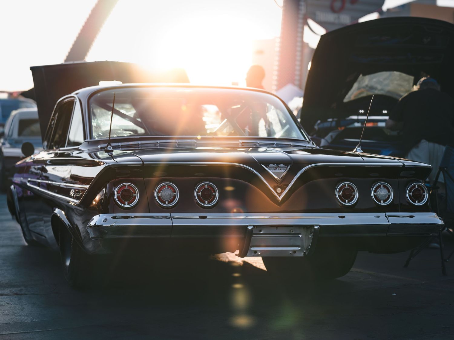 Black classic car with chrome details glowing in golden sunset light at Super Saturday Weekend at The STRAT in Las Vegas