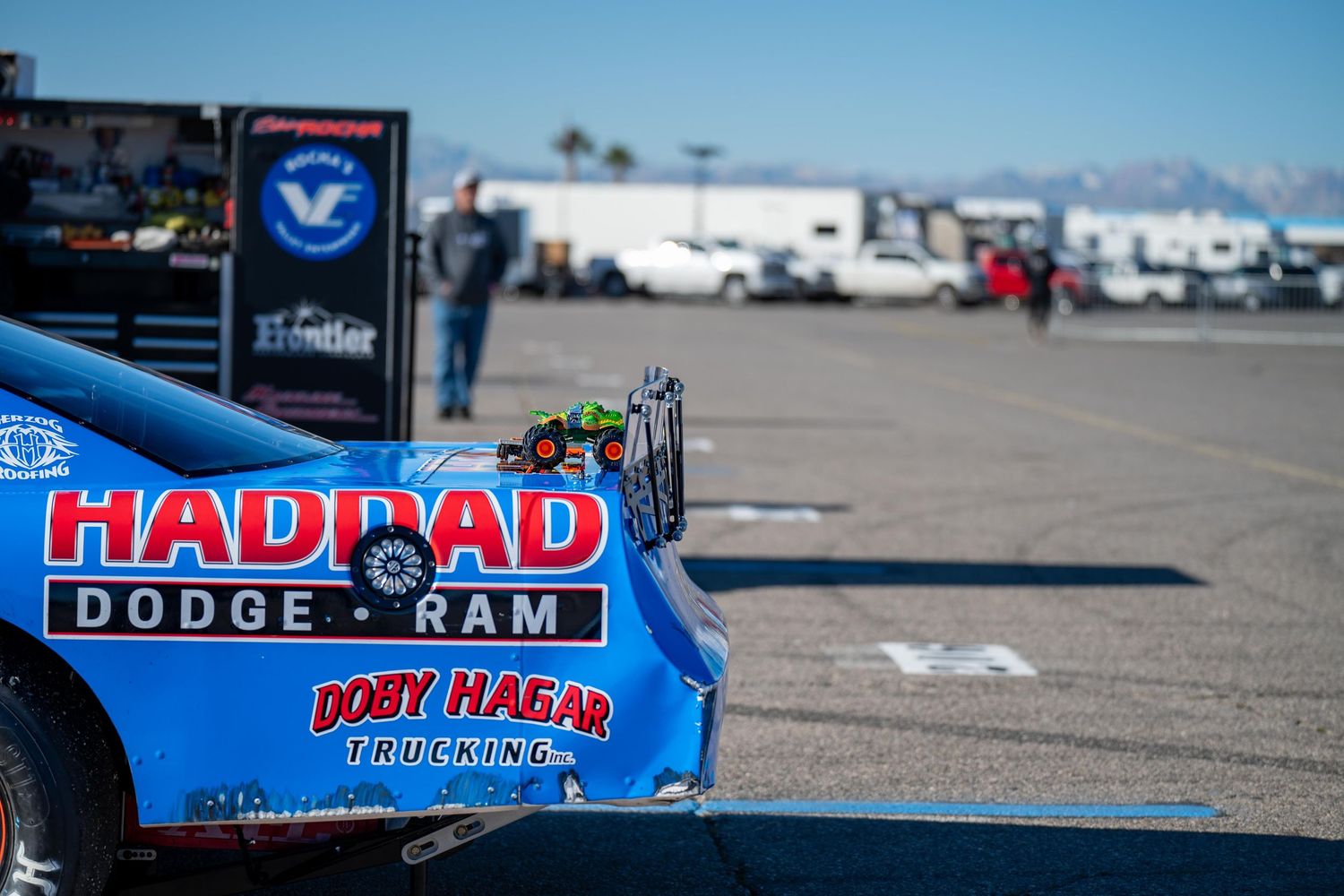 Haddad Dodge Ram racing trailer with Doby Hagar Trucking sponsorship at a motorsports event in a paved paddock area.