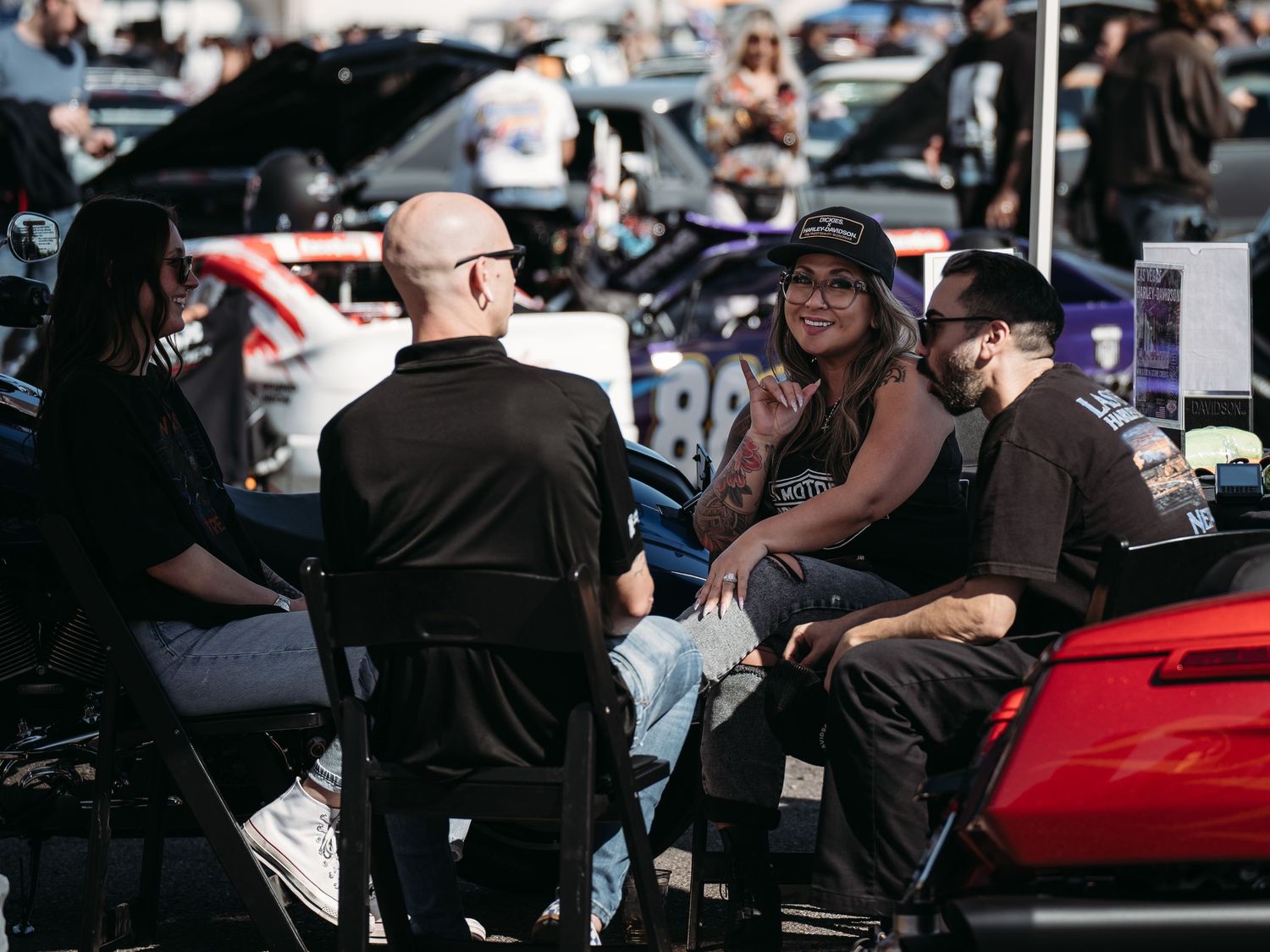 Group of friends relaxing in lawn chairs surrounded by custom cars at Super Saturday Weekend at The STRAT in Las Vegas