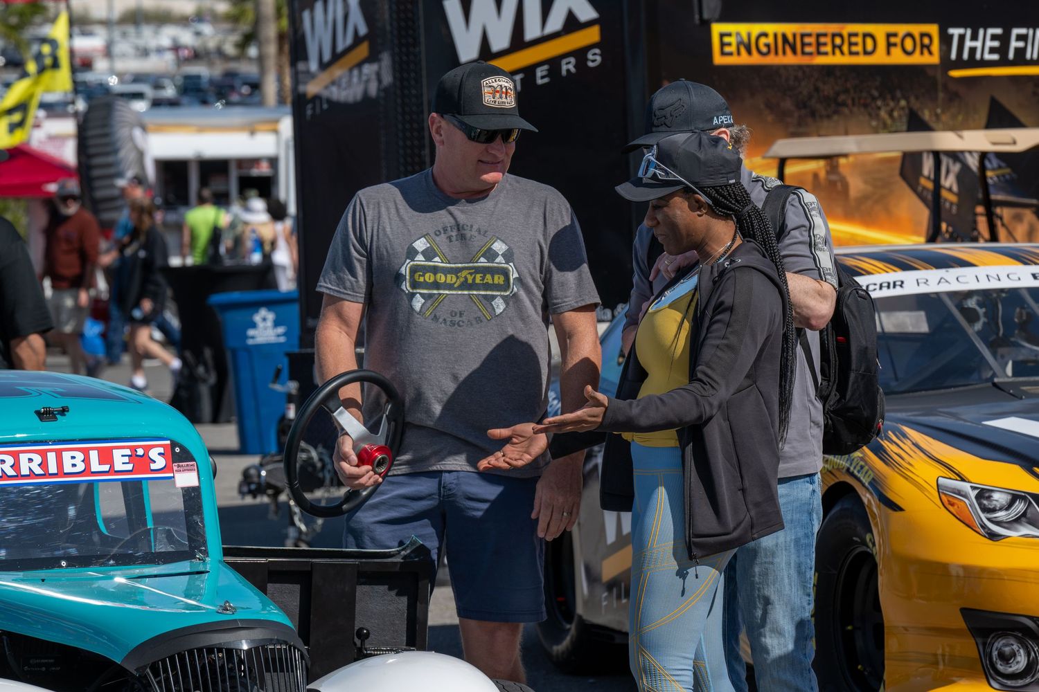 Two people discuss racing details beside colorful LEGENDS at NASCAR