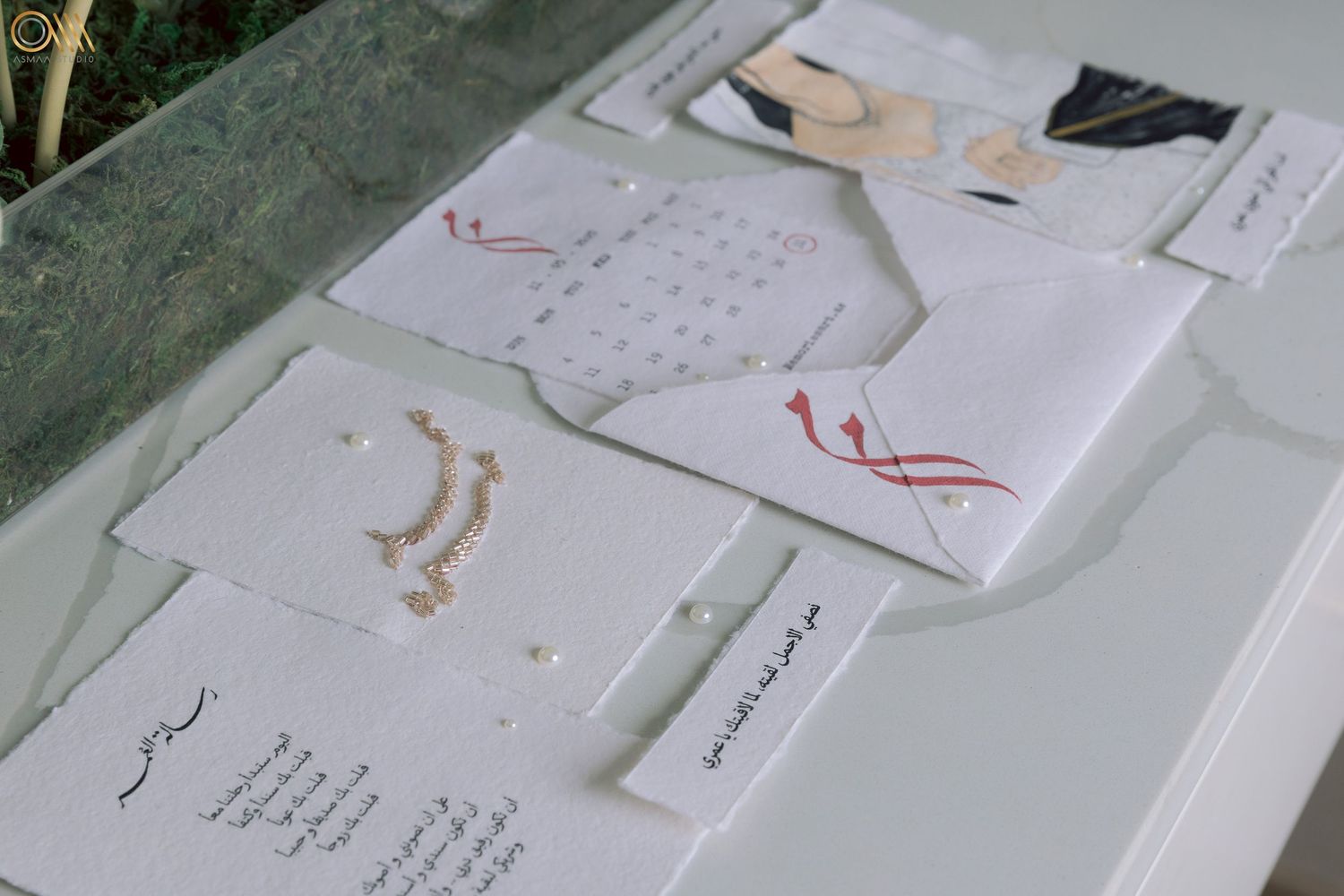 Artistic wedding stationery and invitation cards laid out on a white surface with elegant calligraphy details.