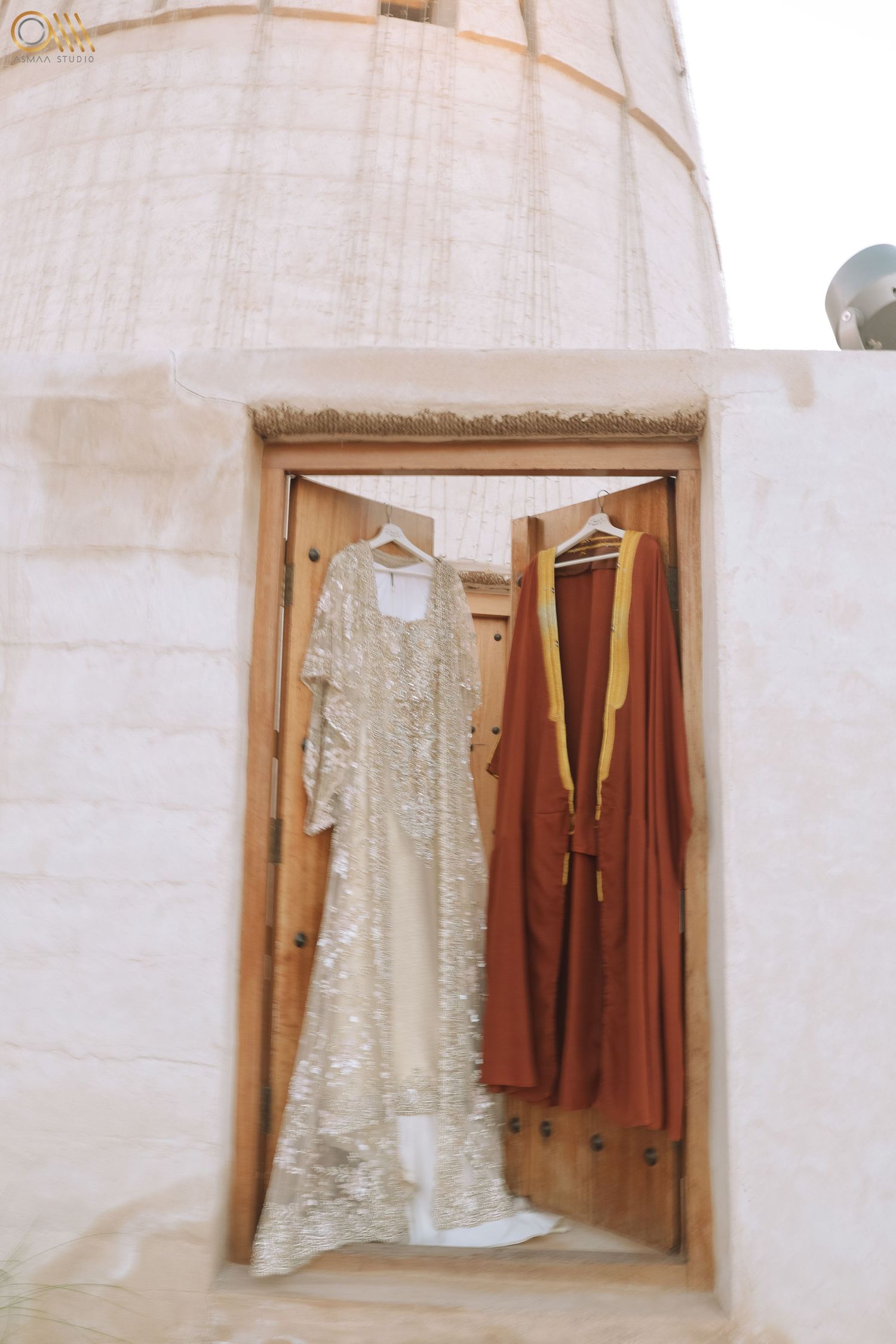 Vintage-style dresses displayed in wooden window frames against white walls.
