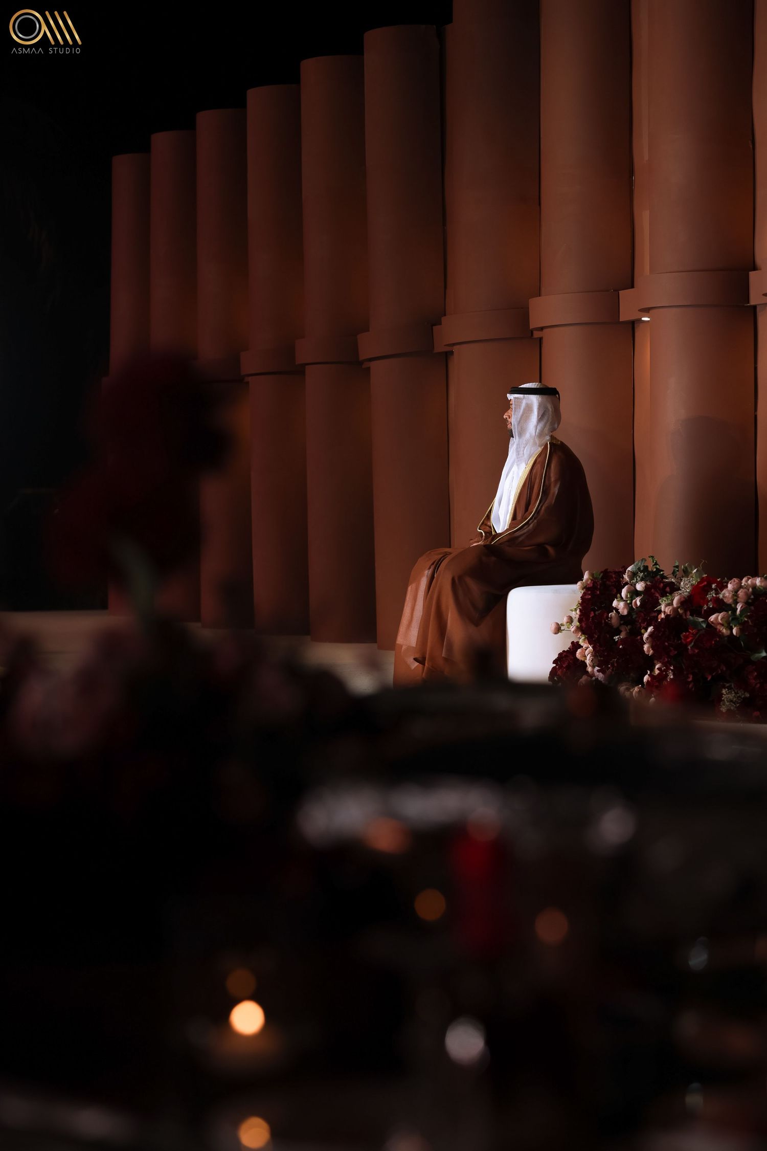 Traditional Middle Eastern wedding ceremony with columned architecture and dramatic lighting.