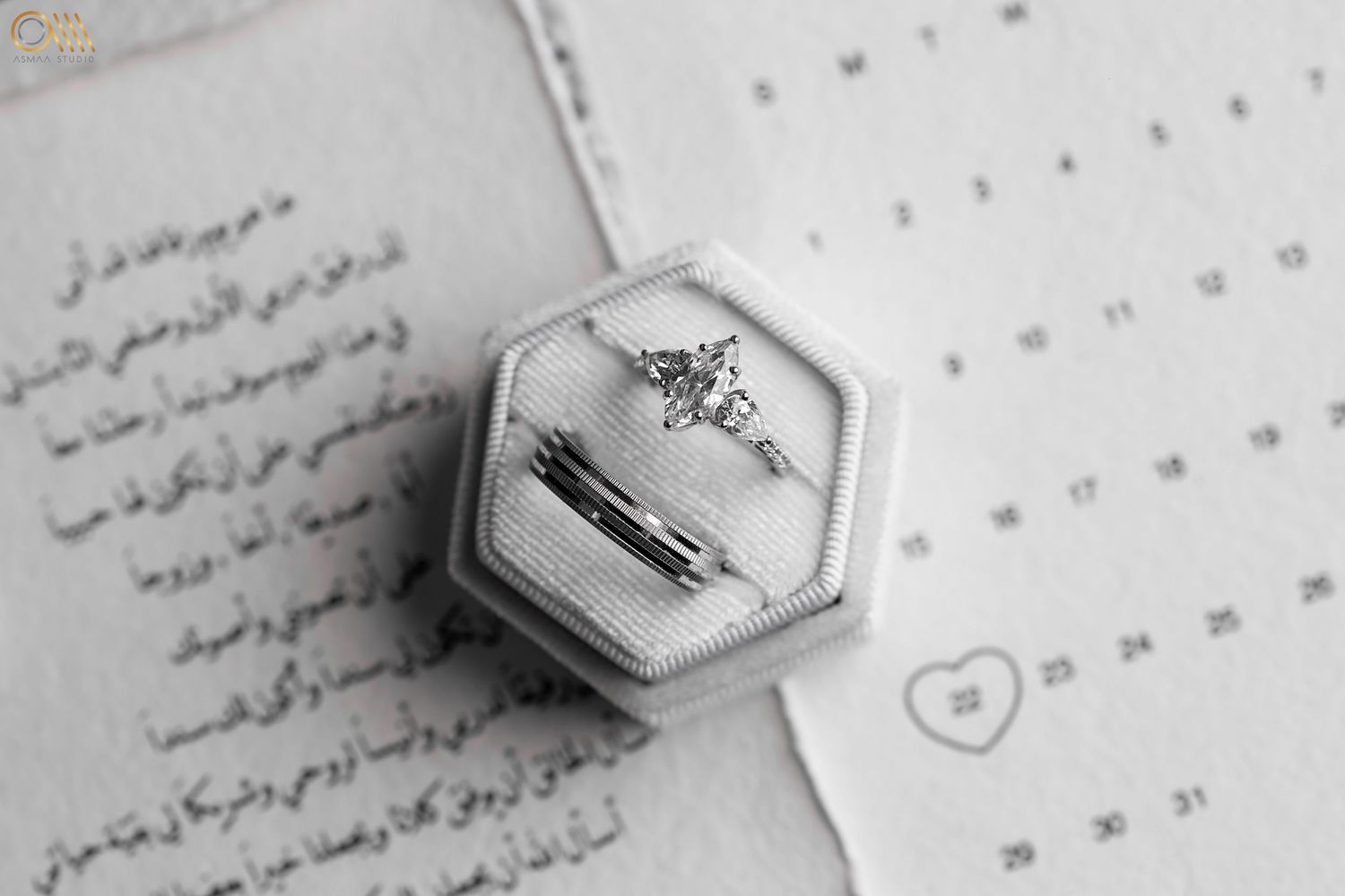 Black and white close-up of wedding stationery with Arabic calligraphy and decorative elements.