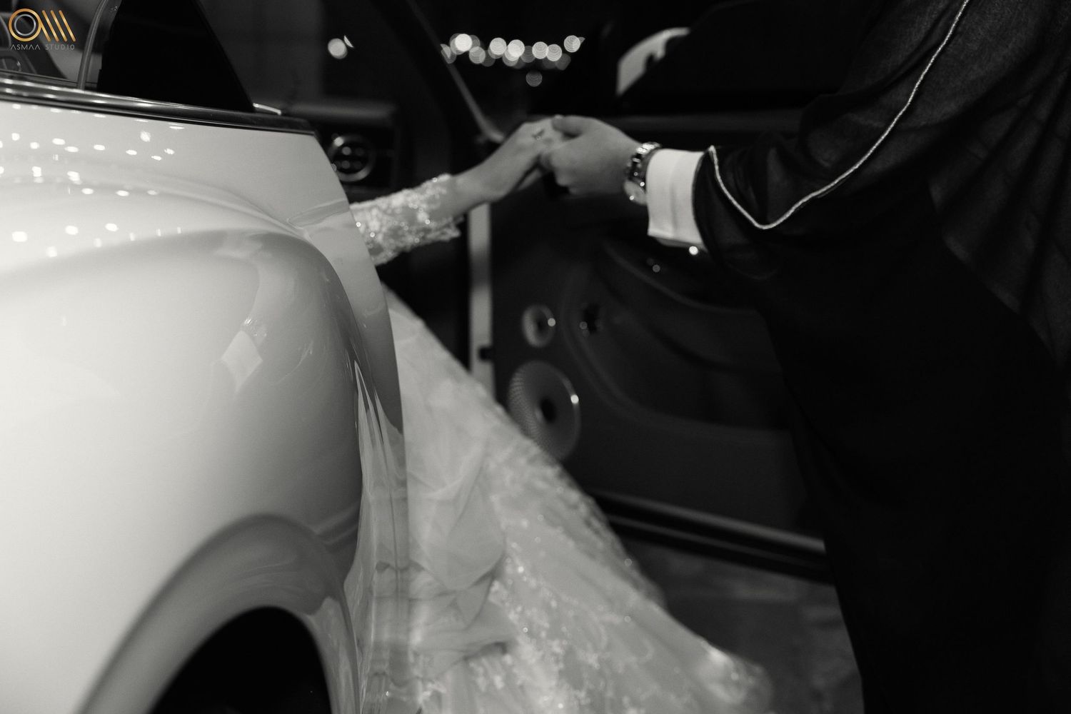 Black and white image of wedding car with tulle decorations at night.