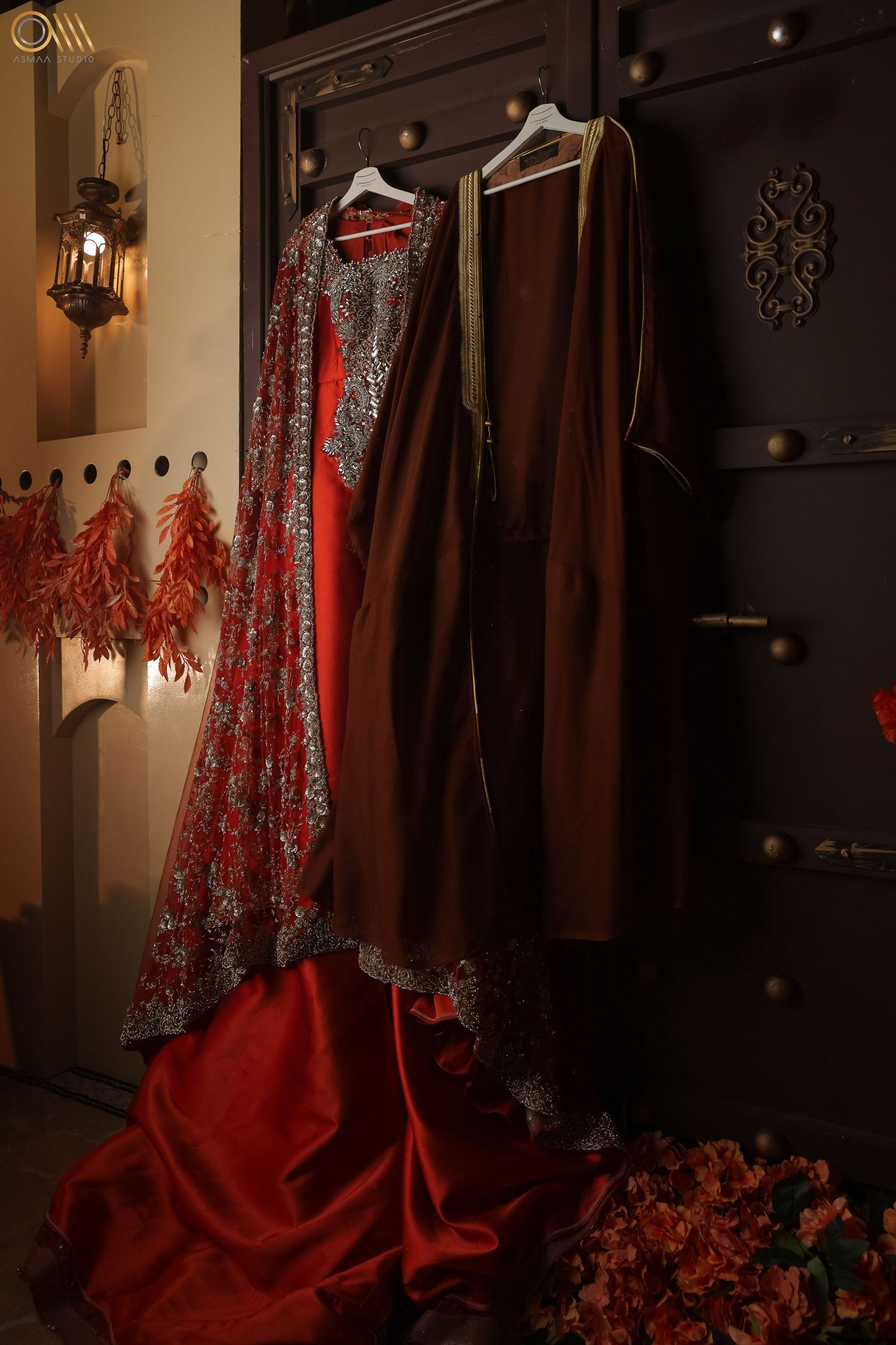 Red and brown formal dresses hanging in an elegantly lit wardrobe display.