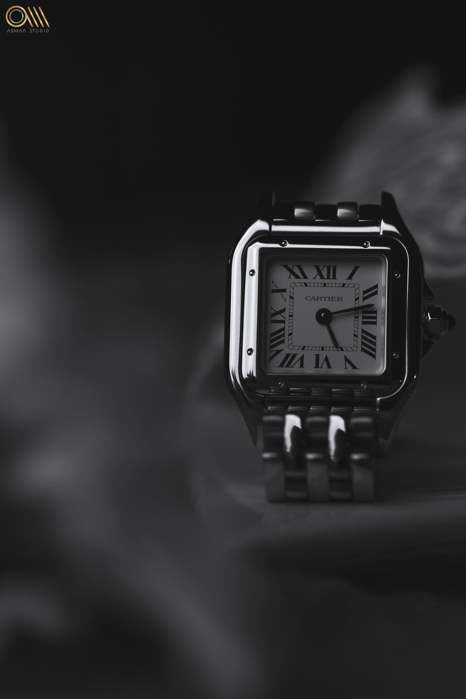 Classic Cartier Tank watch photographed in dramatic black and white lighting.