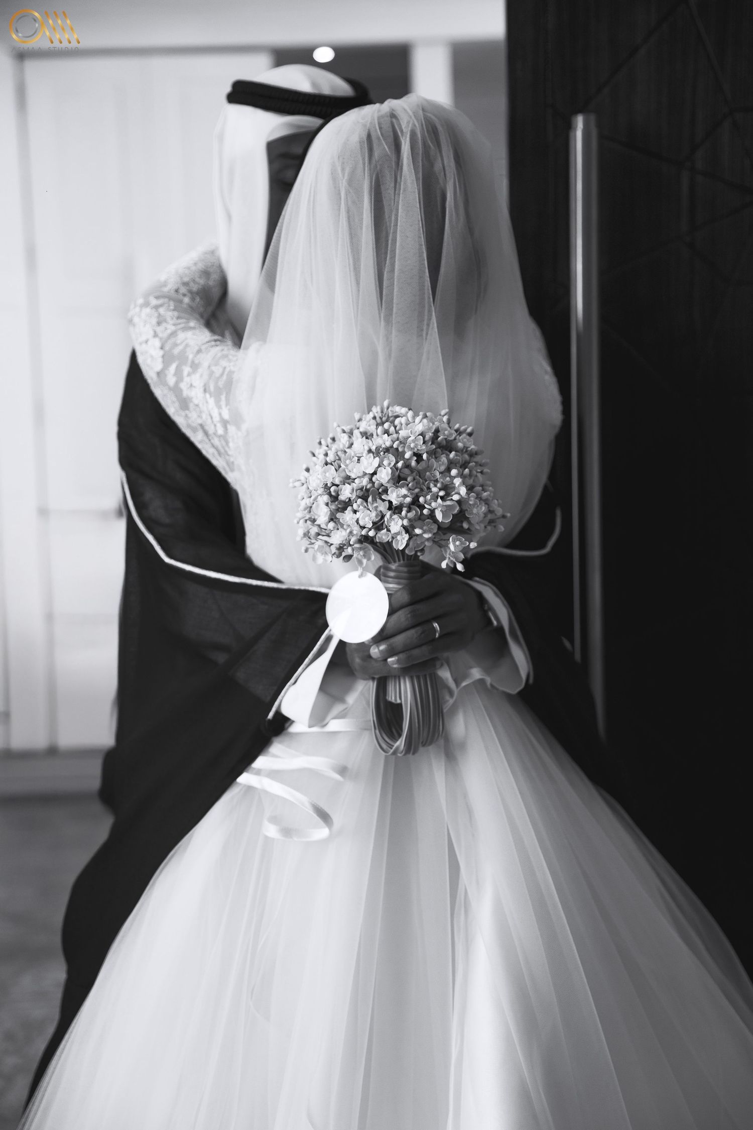 Black and white photo of a wedding dress with delicate floral bouquet details.