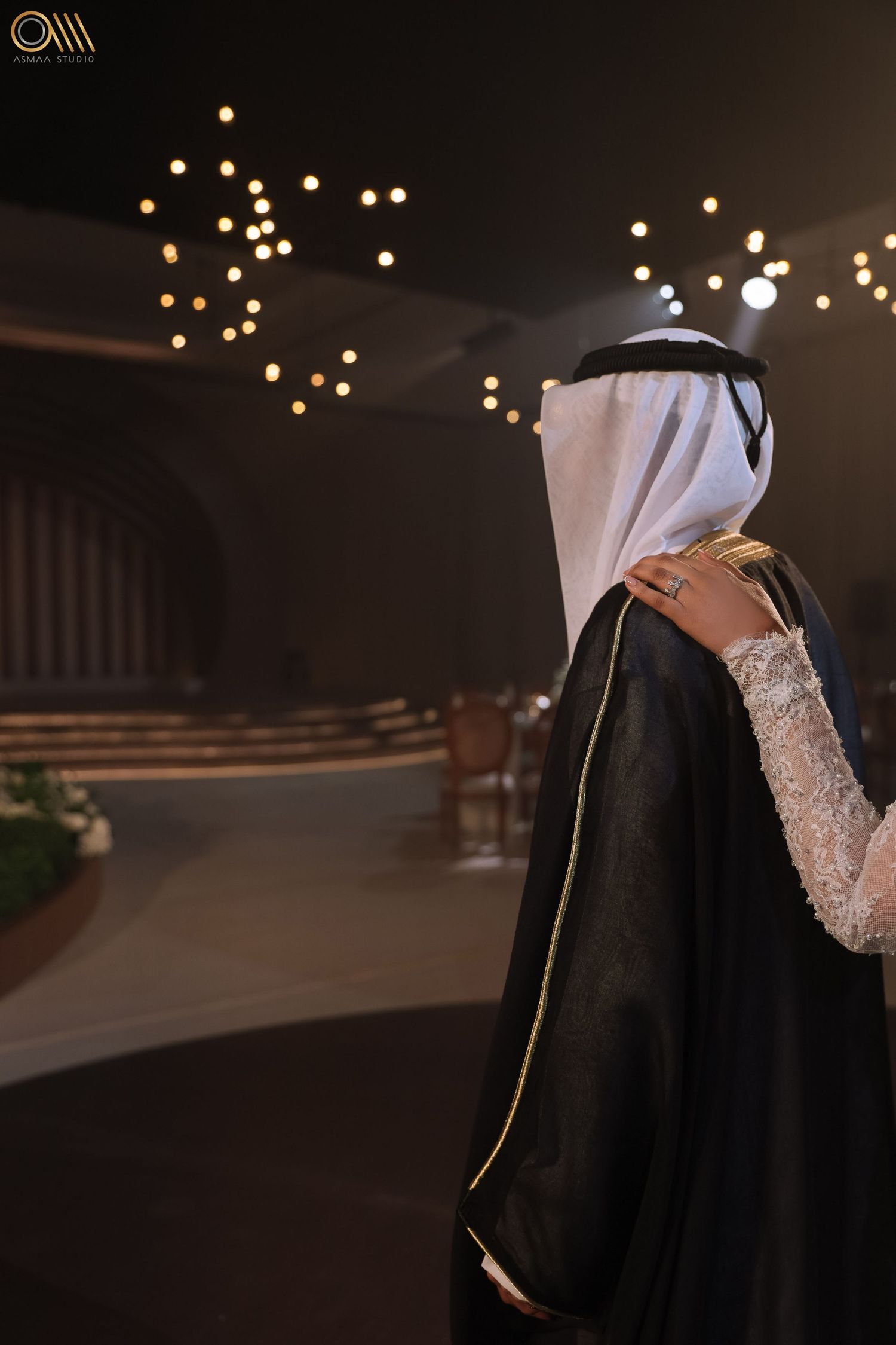 Elegant evening wedding setting with bokeh lights and traditional Middle Eastern formal wear.