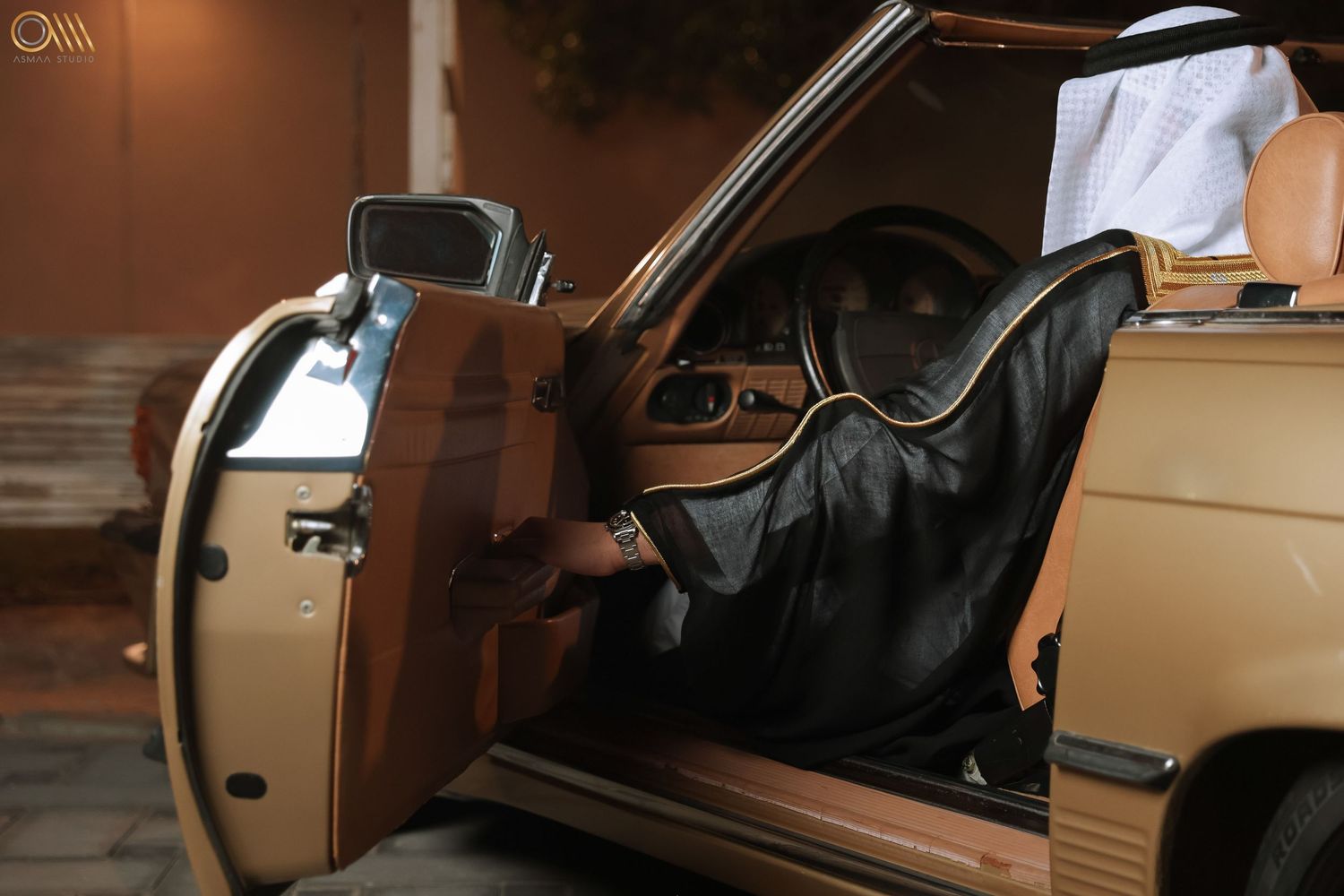 Vintage Mercedes-Benz car interior with open door and tan leather seats.