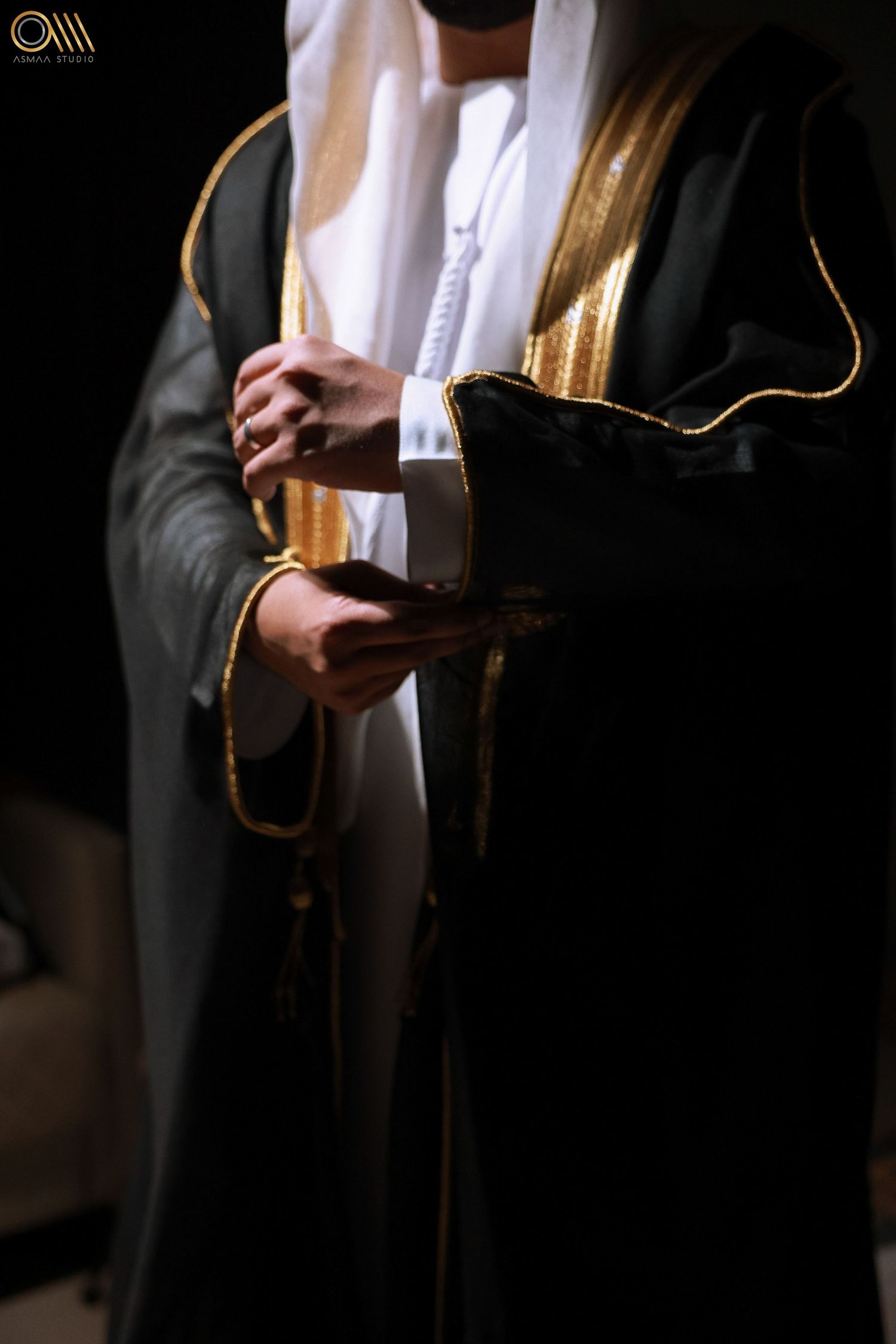 Close-up of hands holding a traditional Arabic marriage contract during a wedding ceremony.