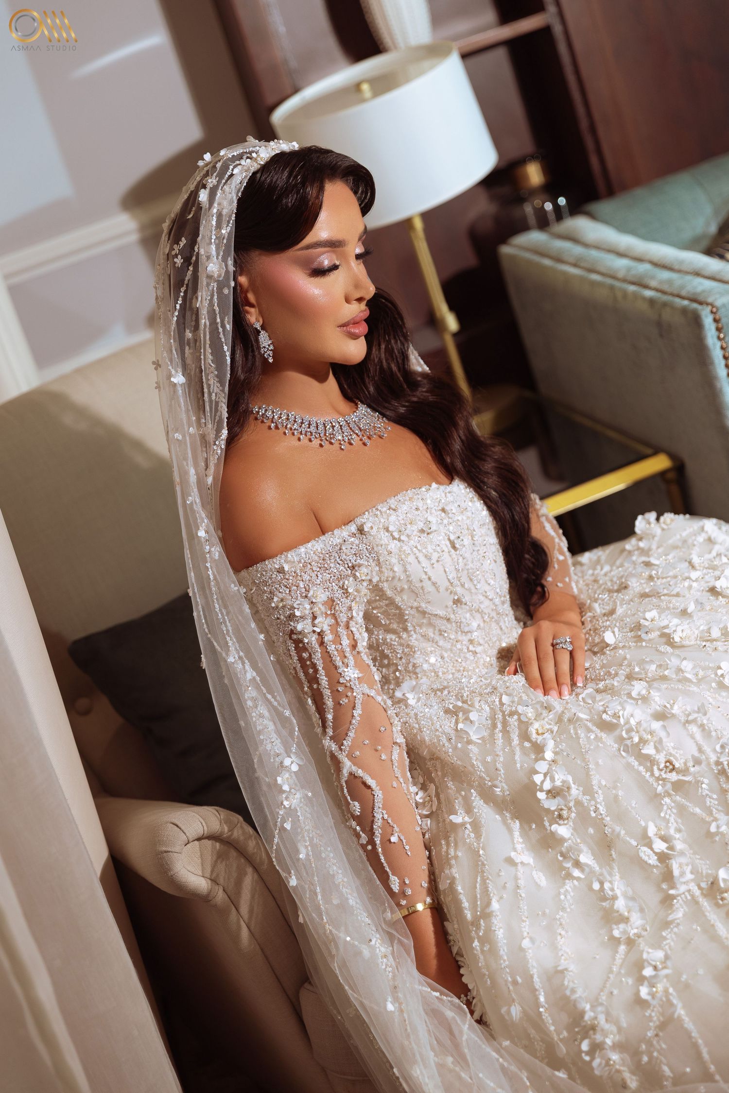 Luxurious off-shoulder wedding gown with intricate beading and lace details.