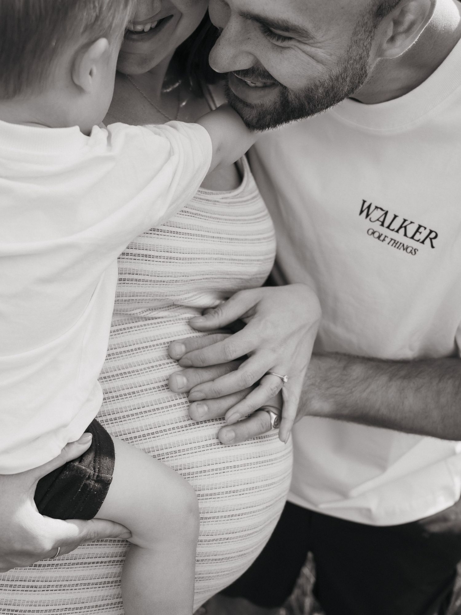 Candid special moment between mum, dad, toddler and baby bump