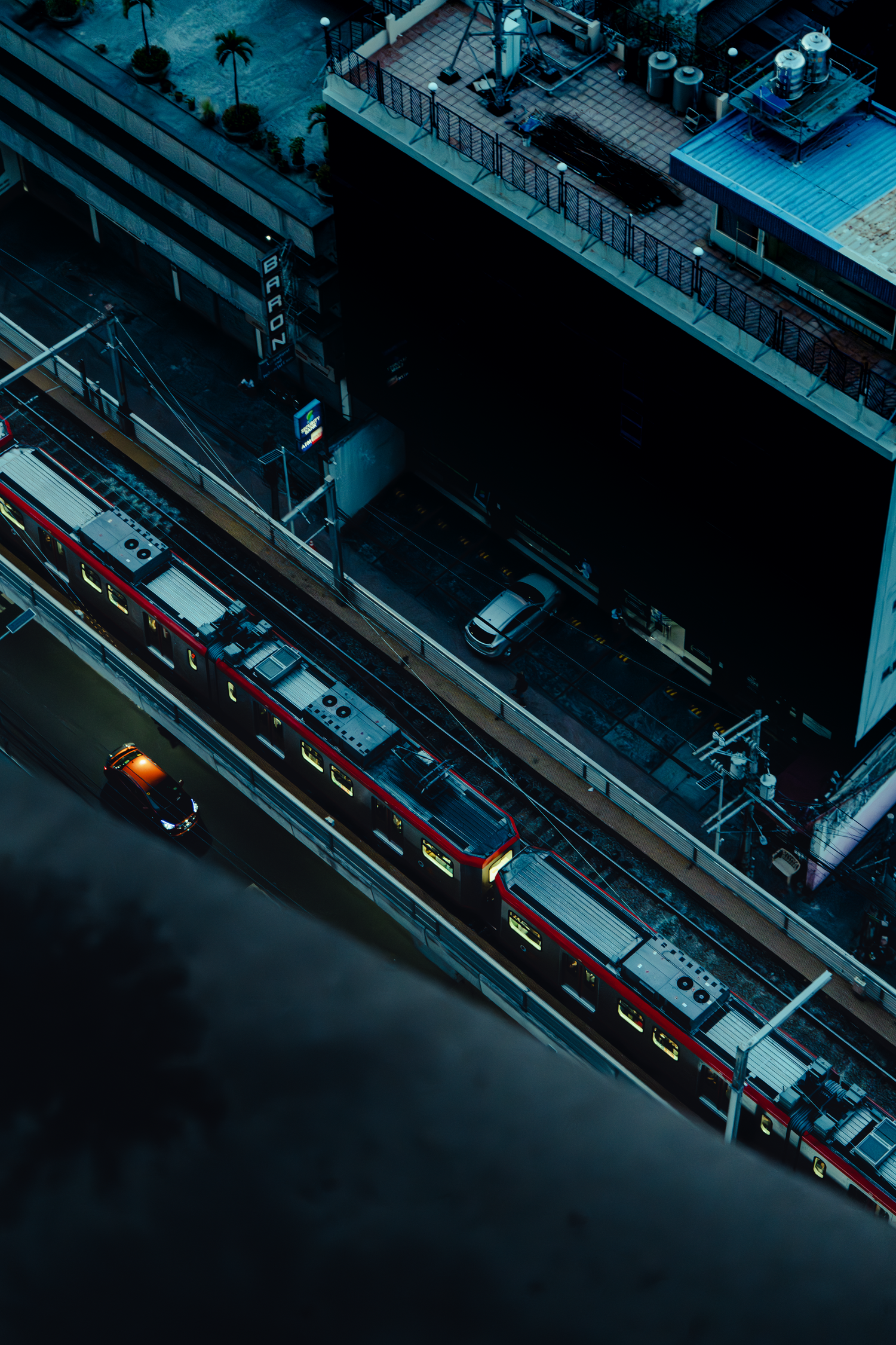 Aerial night view of illuminated city streets with traffic and buildings.