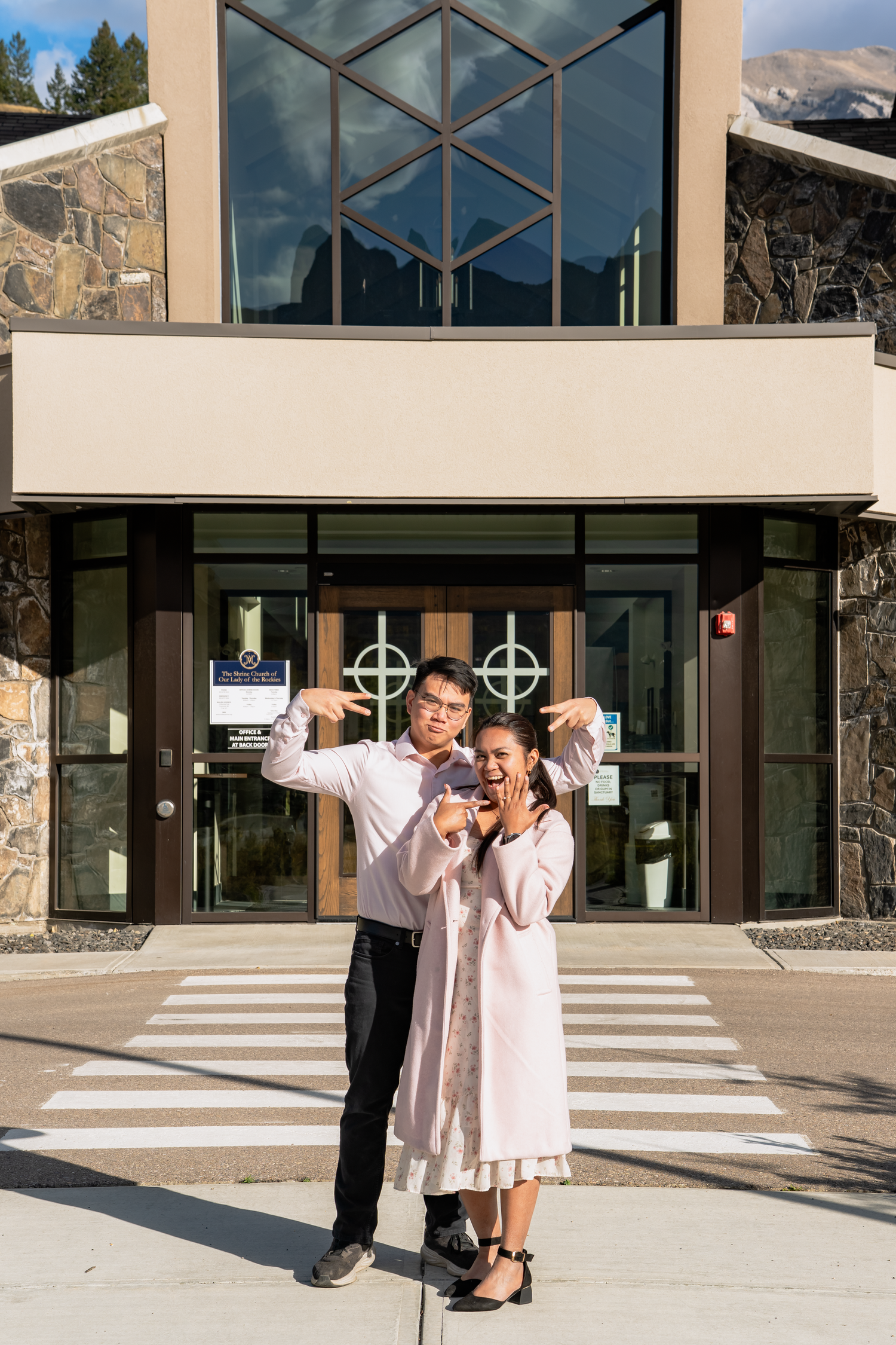 Couple posing playfully outside a church.