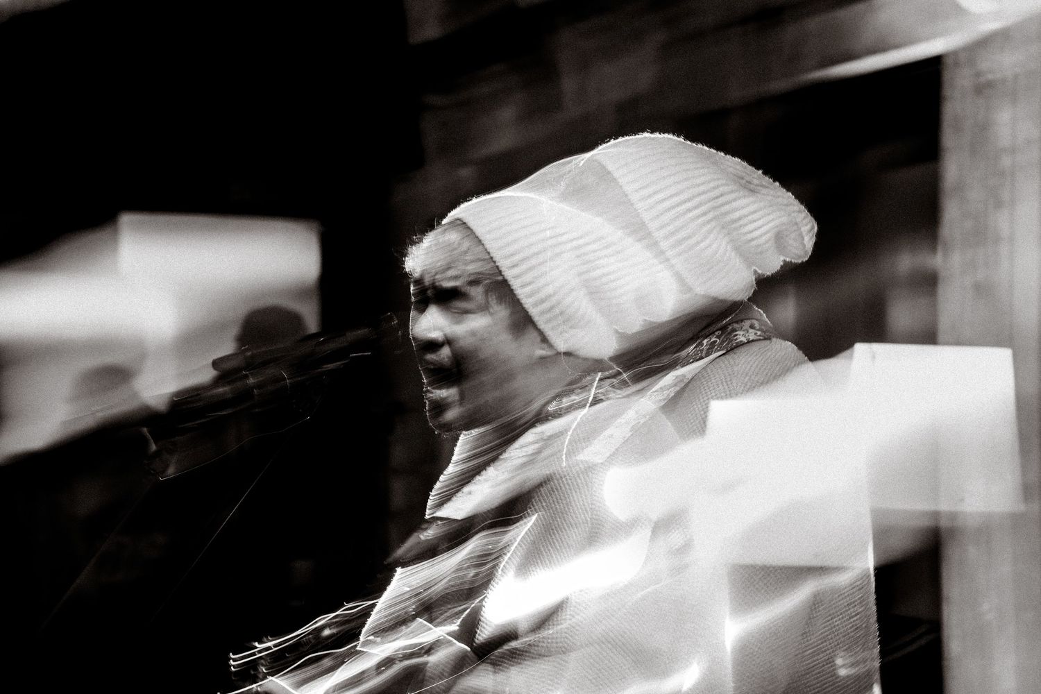 Close-up performance shot of musicians playing instruments in dramatic lighting.