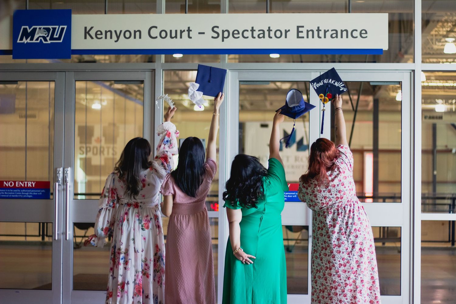 University entrance sign for Kenyon Court Spectator Entrance with glass doors.