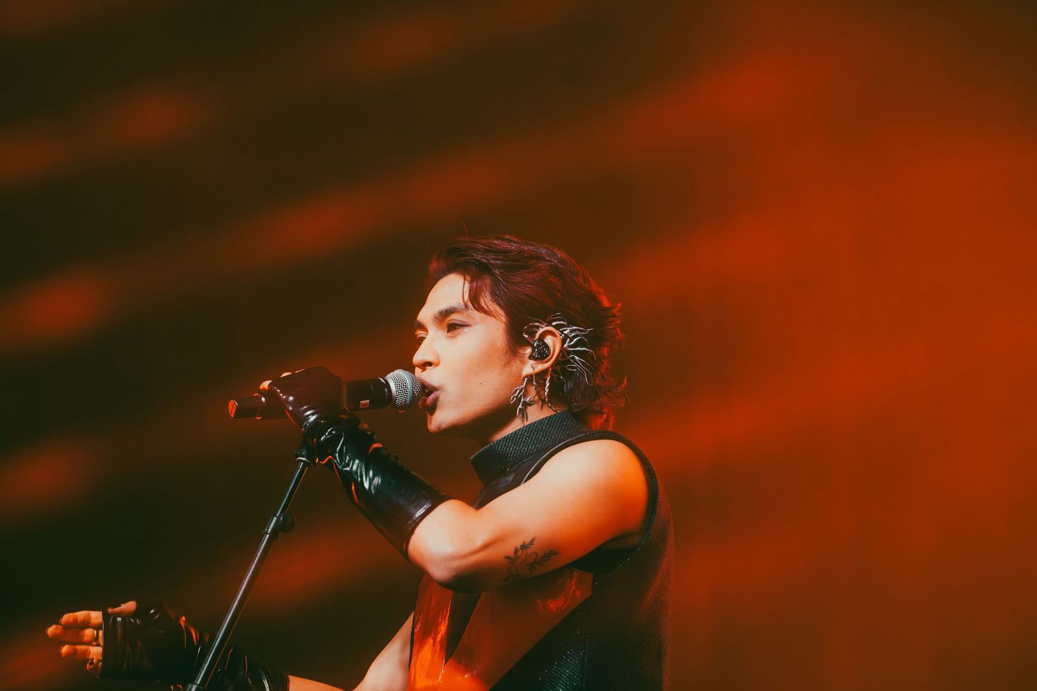 Concert performance bathed in dramatic red lighting and atmospheric stage effects.