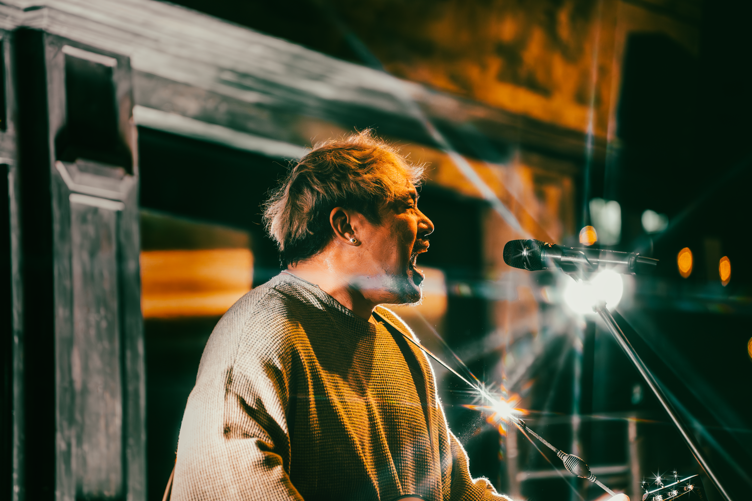Moody concert performance with stage lighting and smoke effects.